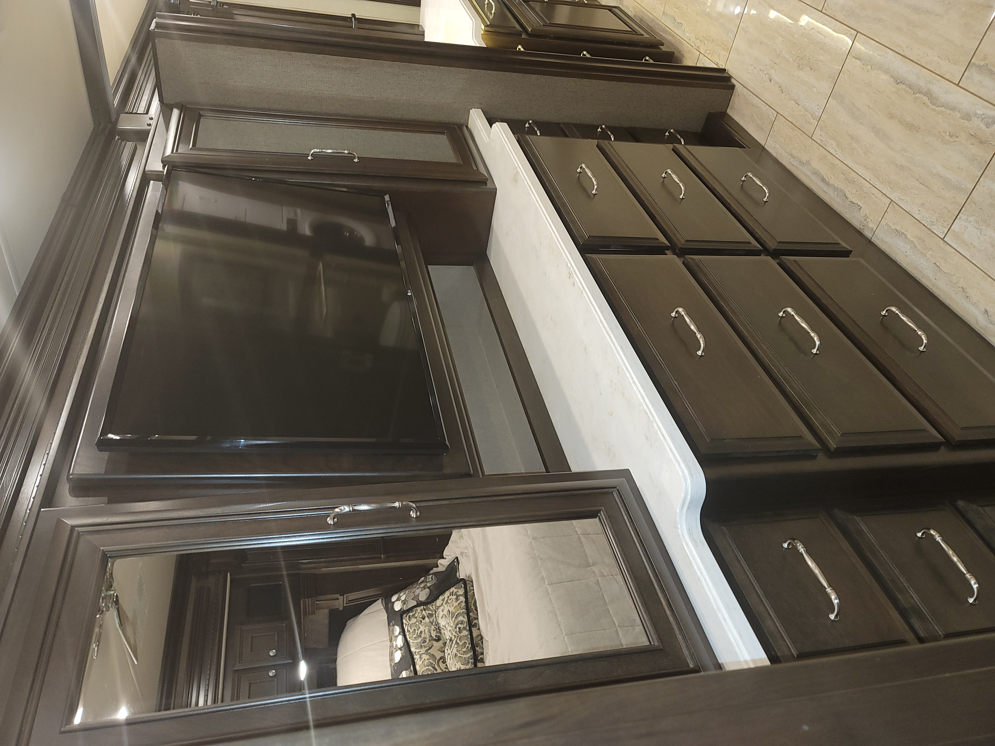 Elegant RV rental interior: dark wood cabinetry, TV, and mirror offer ample storage. A cozy, residential feel for your journey.. Monaco Marquis 2019