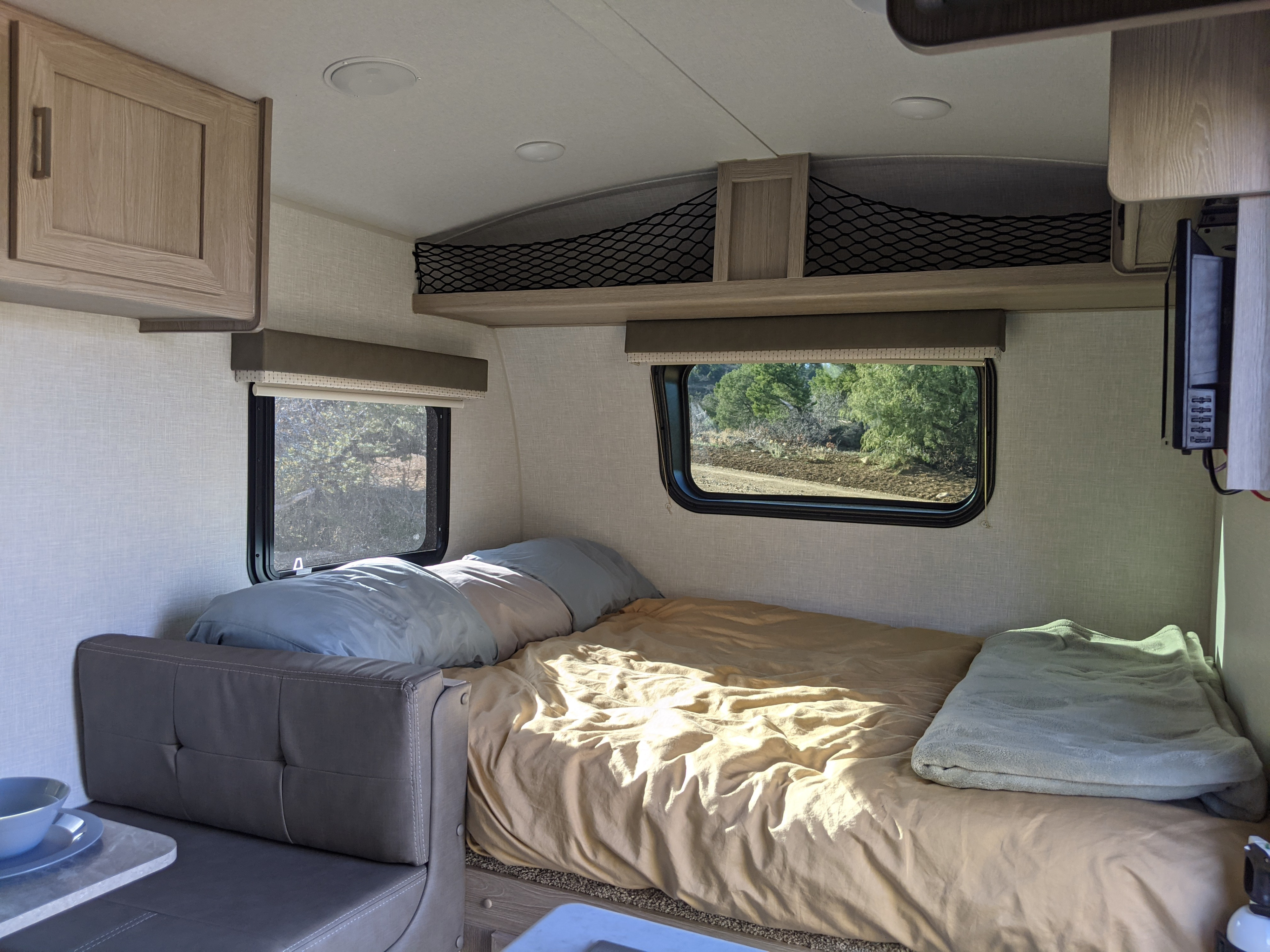 Spacious rv rental interior featuring a comfy bed, dinette, and large windows with outdoor views. Ideal for road trips.. Forest River Geo Pro 19BH 2021