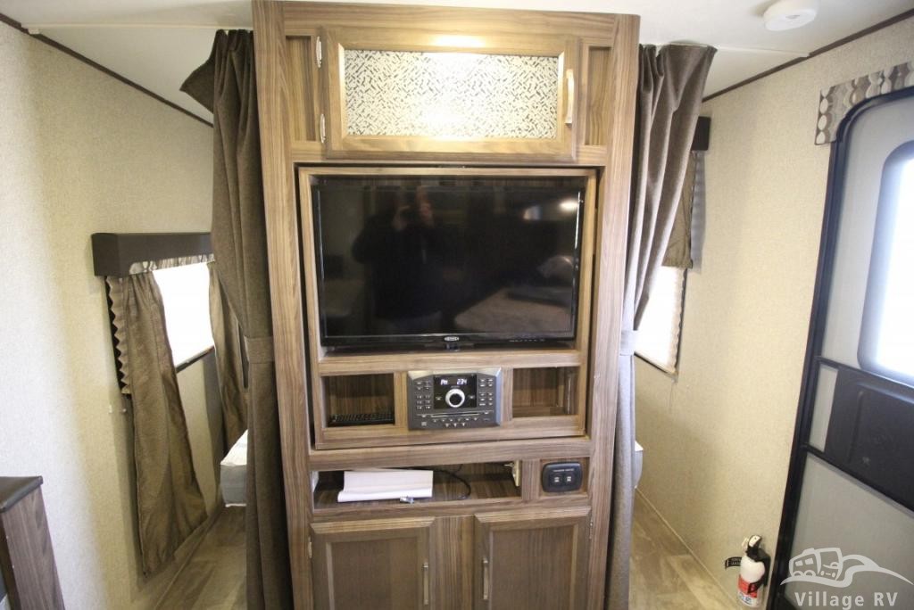 RV rental interior: A central wooden entertainment unit with TV & stereo, flanked by privacy curtains leading to other cabin areas.. Coachmen Other 2019
