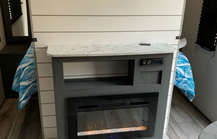 RV rental: Modern interior features a central media console with electric fireplace, flanked by cozy beds.. Aspen Other 2021