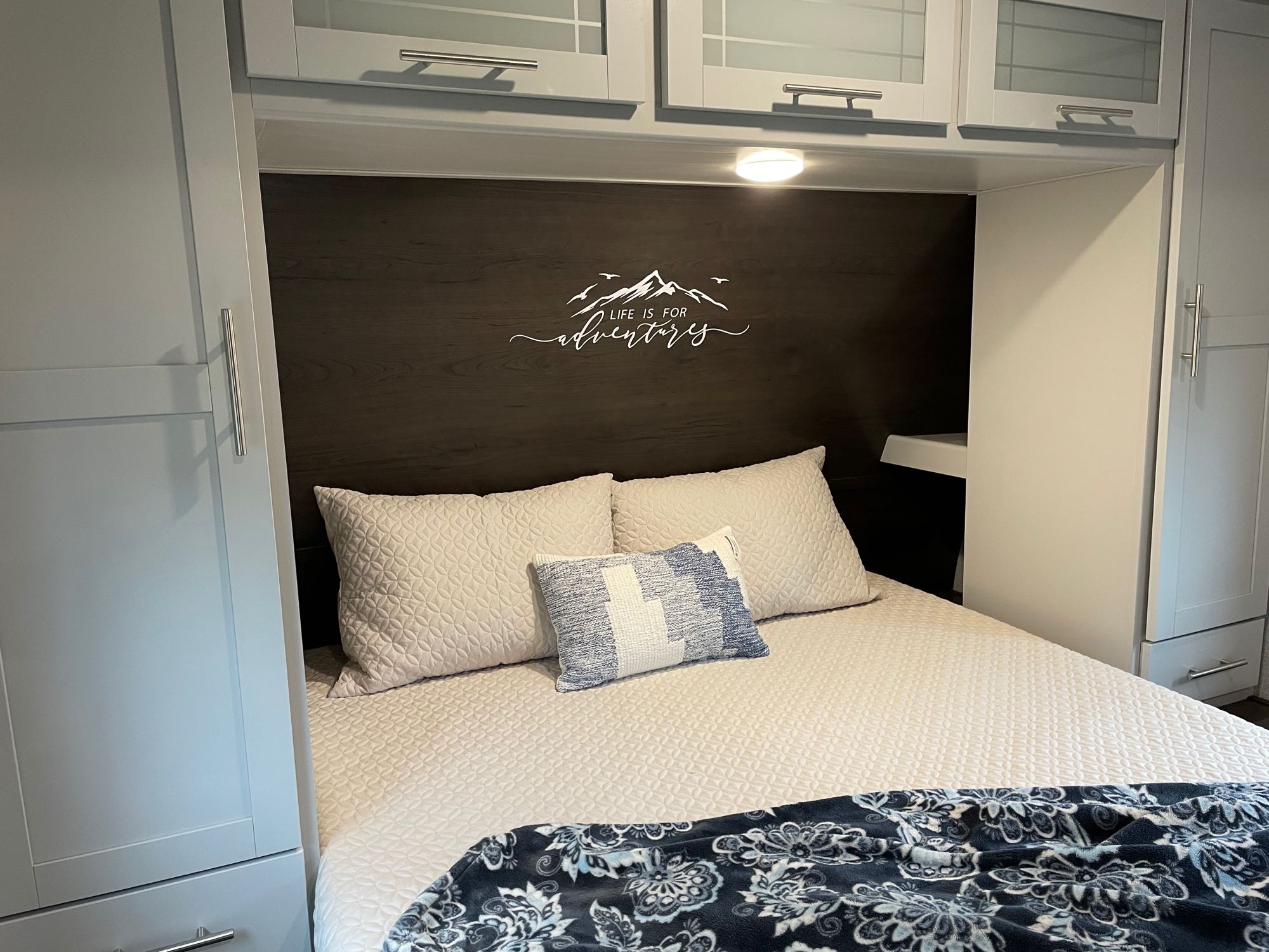 Comfortable RV rental bedroom with inviting bed, pillows, and ample surrounding cabinetry for a cozy stay.. Keystone Bullet Ultra Lite 2021