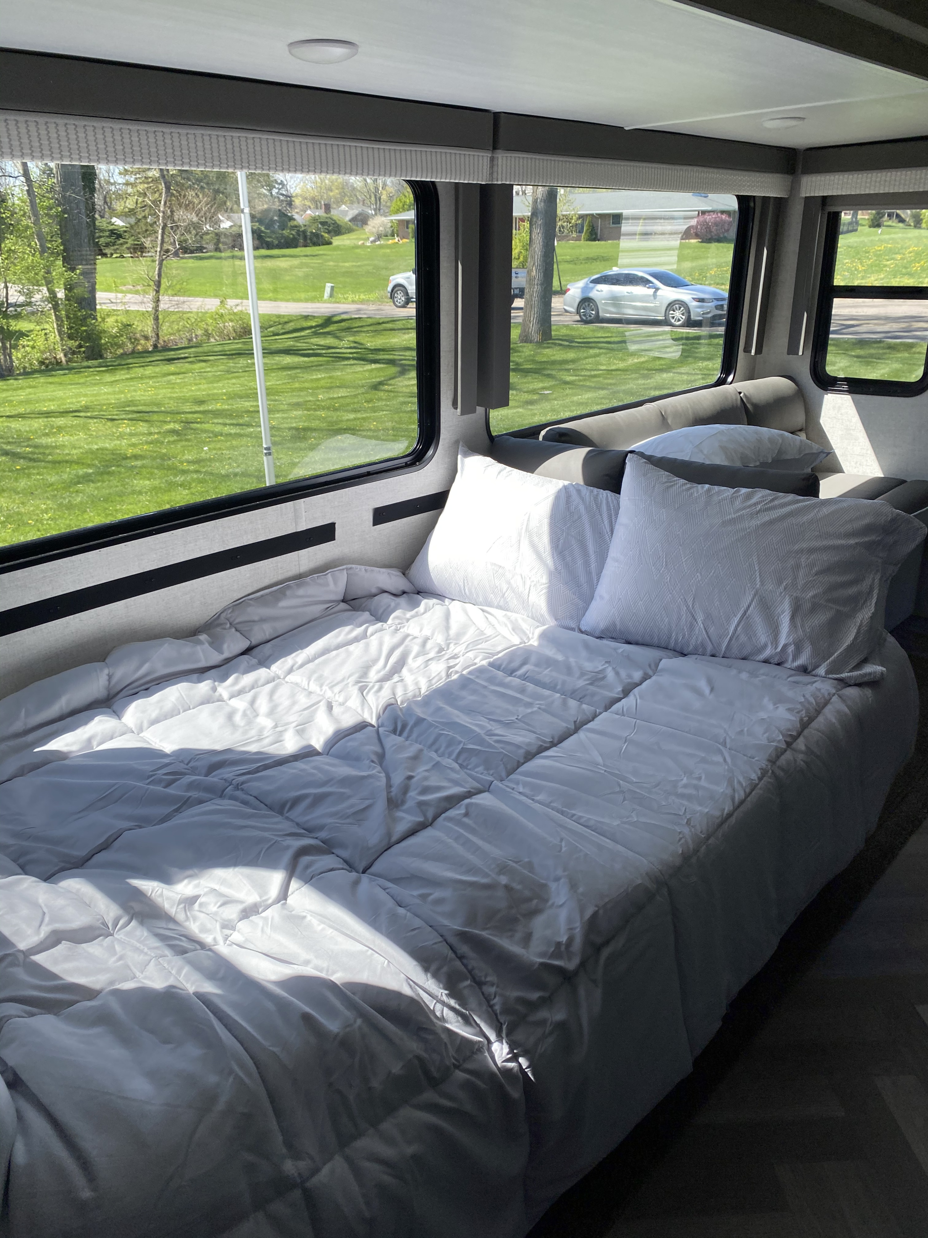 Cozy RV rental bedroom with large windows and sunny outdoor views.. Forest River Other 2021