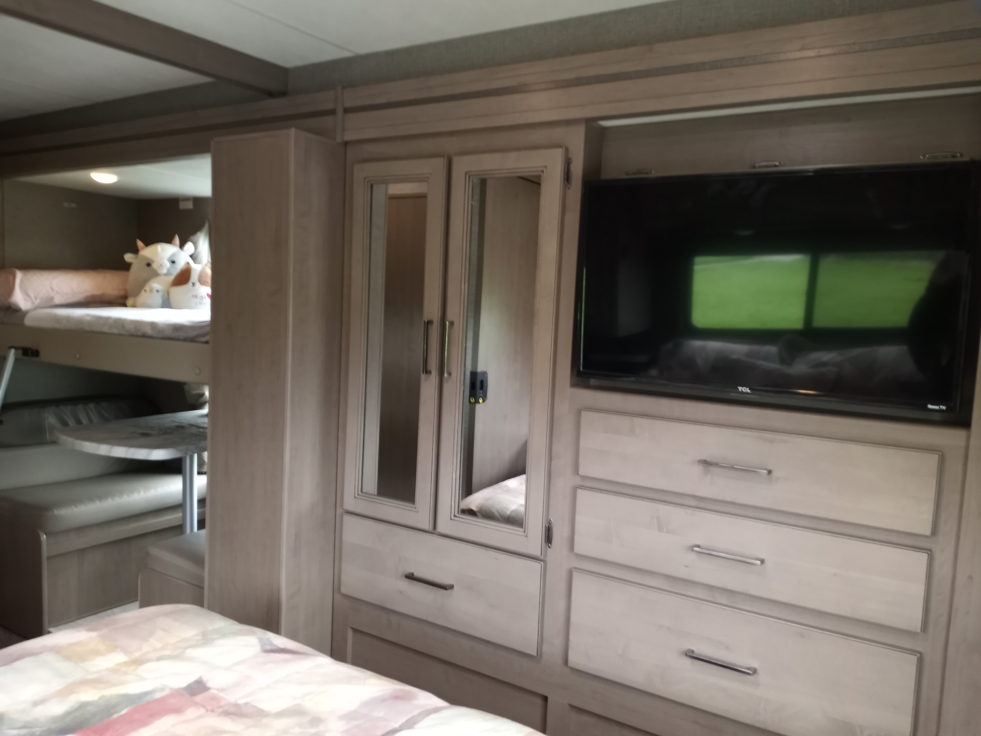 Inside this RV rental: bunk beds, a dinette, and a TV entertainment unit with ample storage. Ideal for families.. Coleman Thor 2021