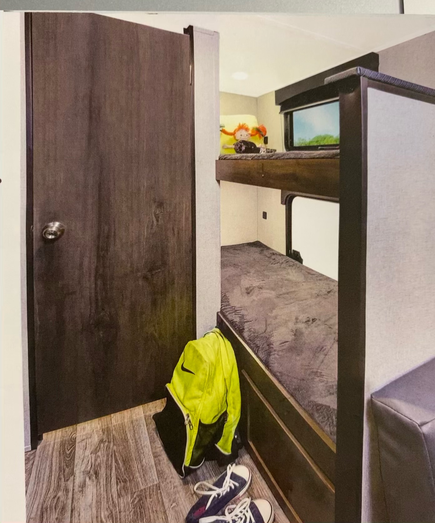 RV rental interior: a dark door, compact bunk beds with an outdoor view, and travel gear on laminate flooring.. Viking 17BH 2021