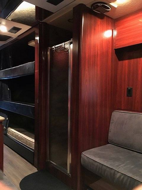Luxury RV rental interior with bunk beds, private shower, and comfy seating. Ideal for group travel.. Prevost Le Mirage 2003