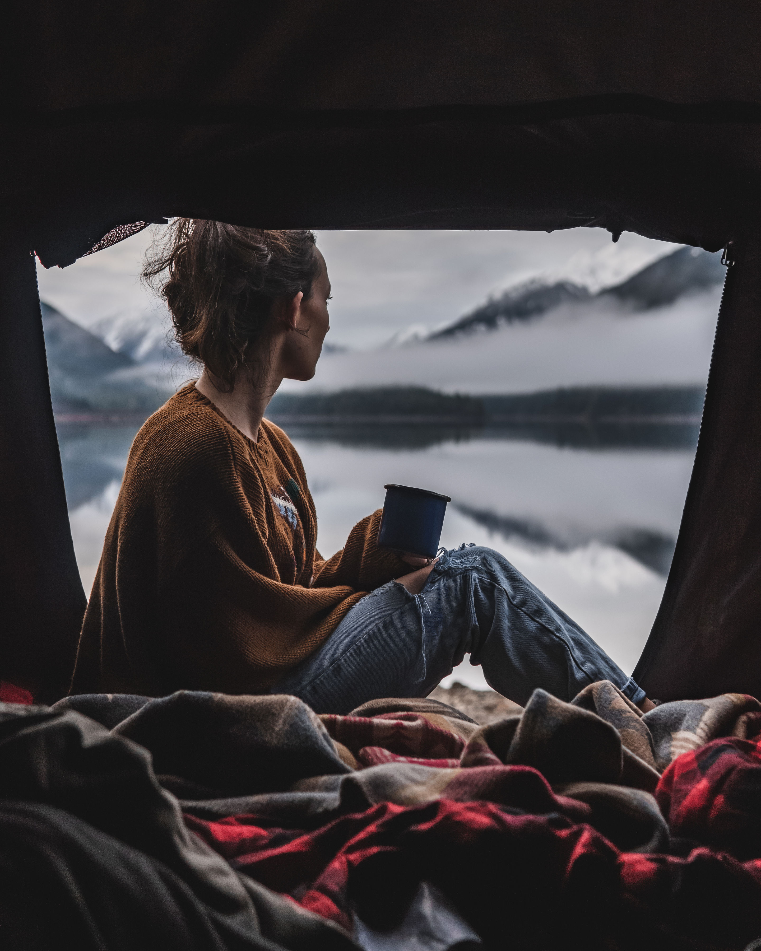 Enjoy a cozy morning from your **RV rental**, overlooking a misty mountain lake. A person sips coffee, bundled in blankets.. Toyota 4Runner 2021