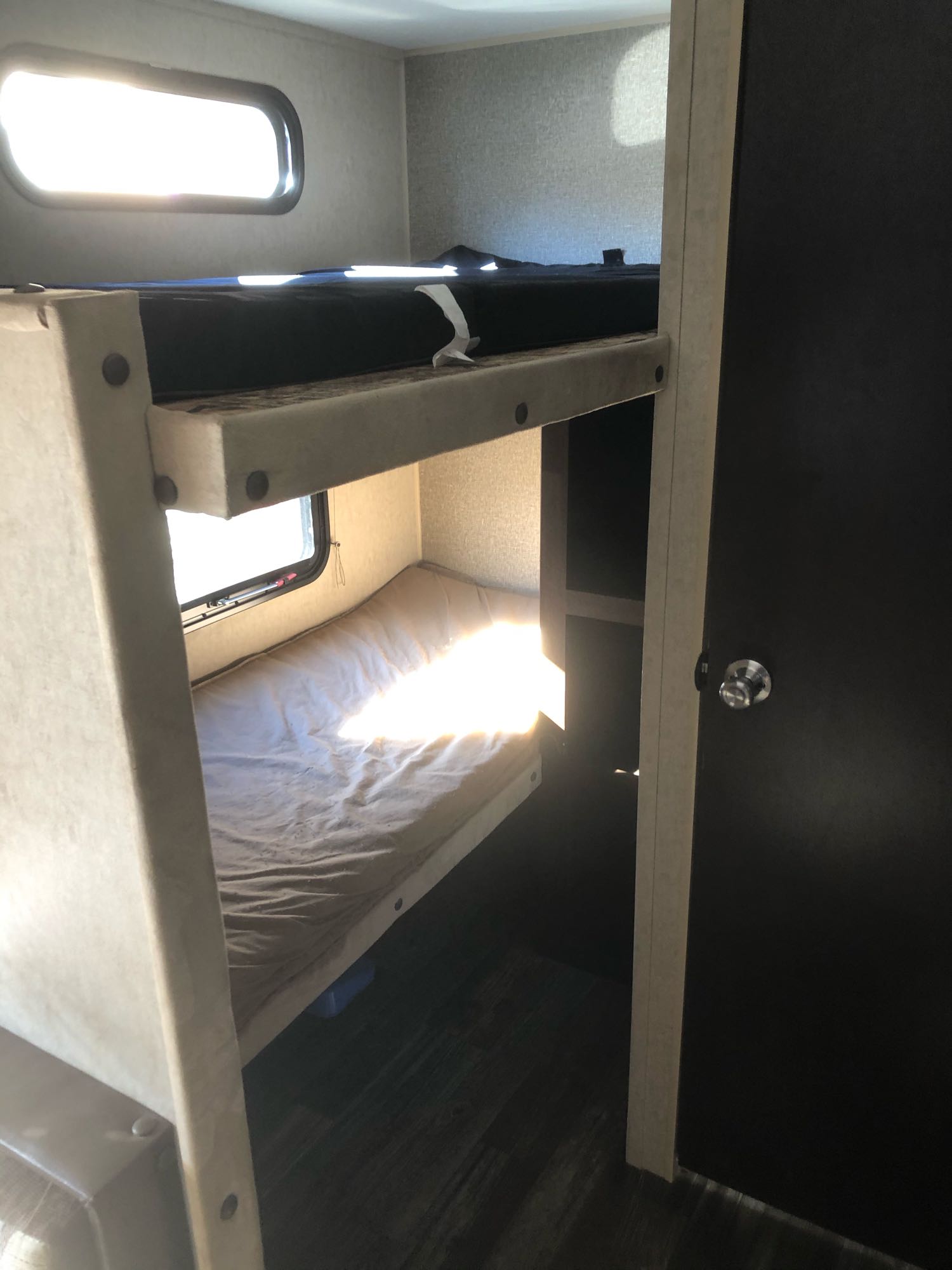 A cozy interior of an RV rental features bright bunk beds with windows, perfect for family travel.. Forest River Cherokee Grey Wolf 2016