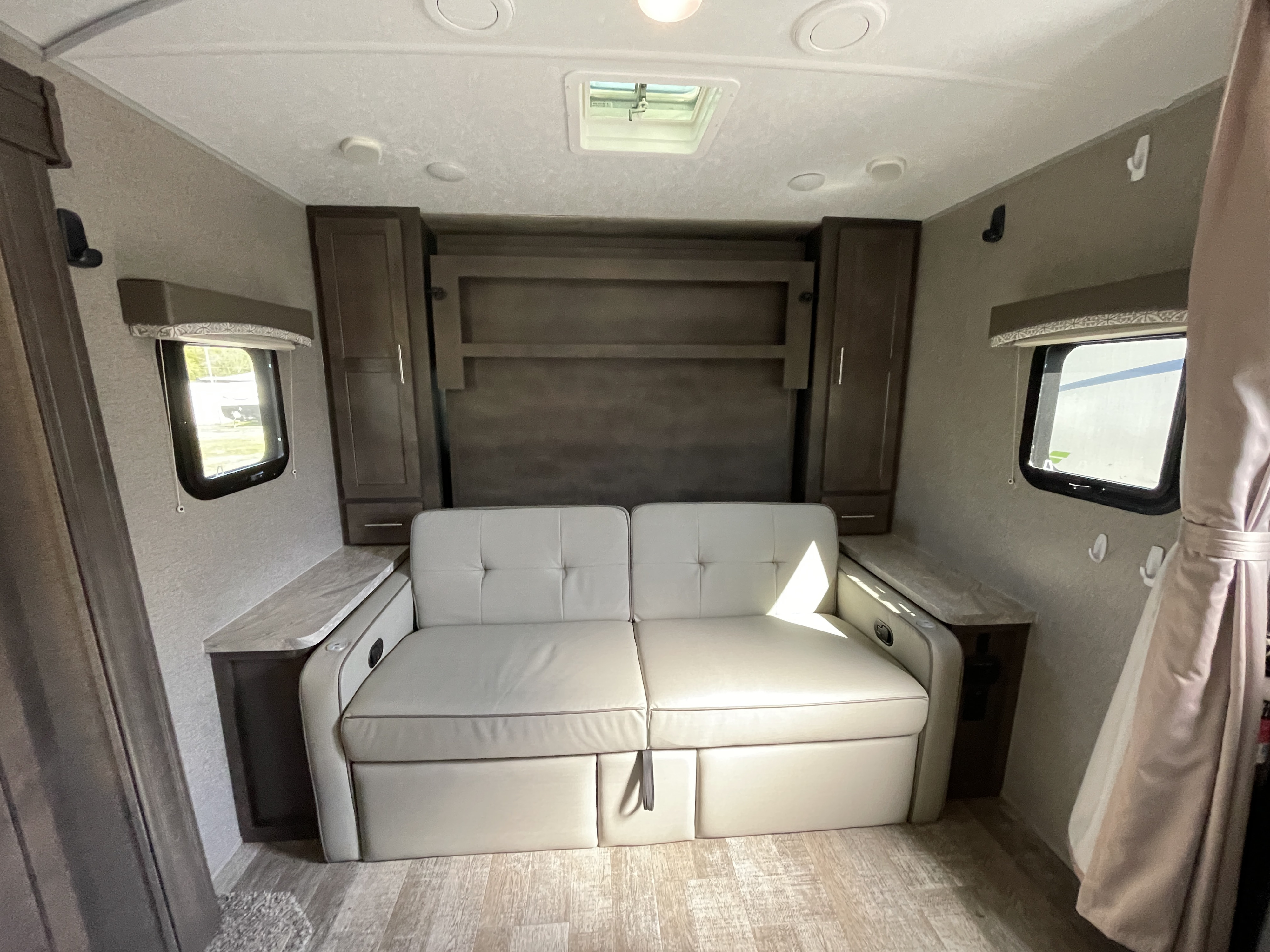 Cozy RV rental living area with a light sofa that converts to a bed, side storage, and windows for natural light.. Forest River Rockwood Mini Lite 2020