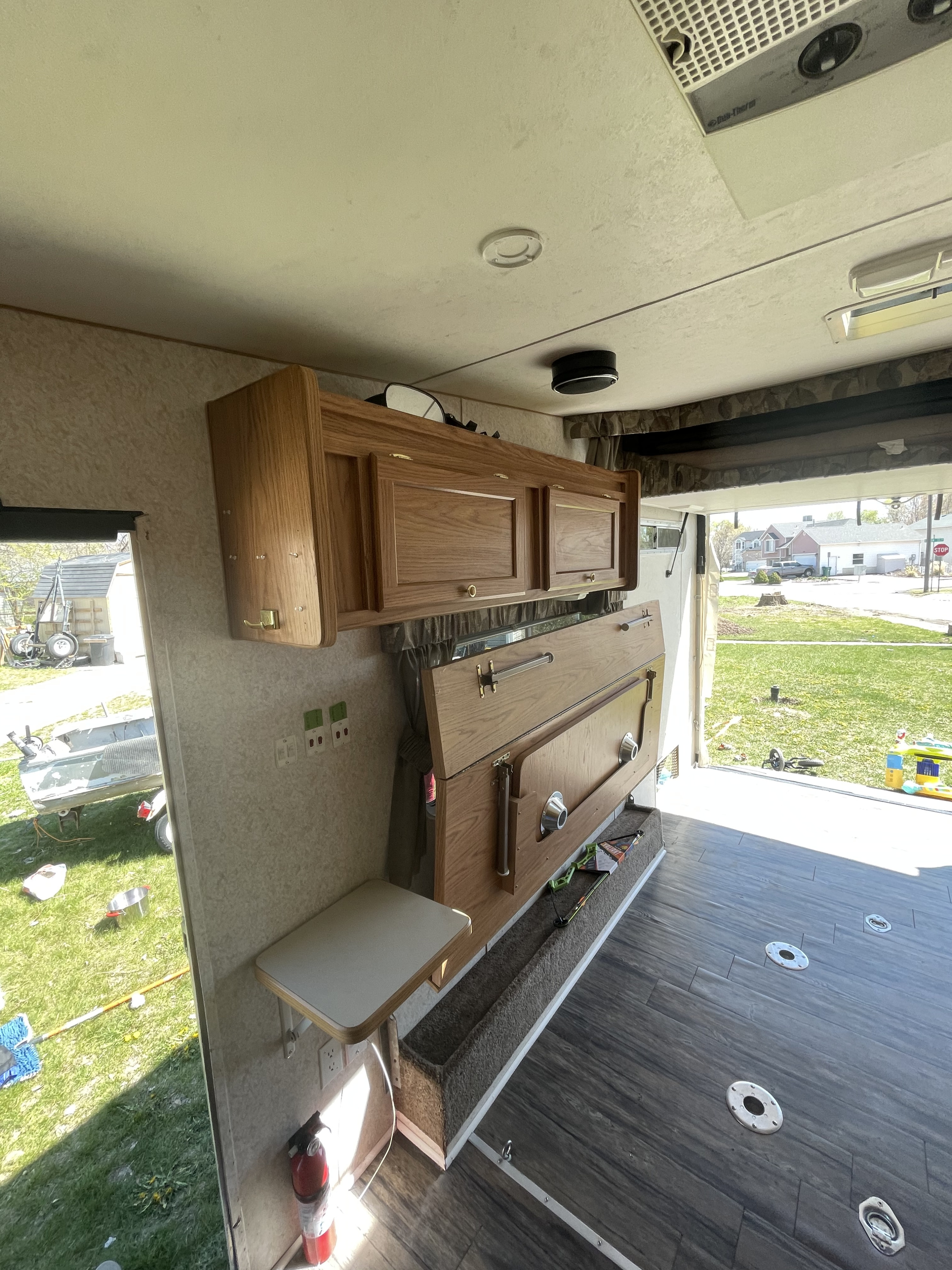 RV rental toy hauler interior: wood cabinets, durable floor with tie-downs, and an open rear ramp.. Weekend Warrior 1900fk 2005