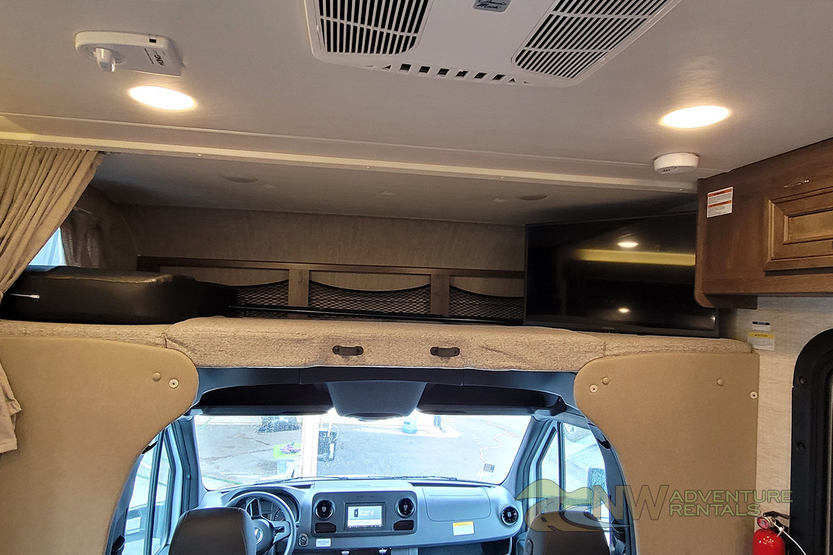 Inside this RV rental, see the cozy overhead bunk bed, front cab, TV, and ceiling amenities like AC and lights.. Jayco Melbourne 2021
