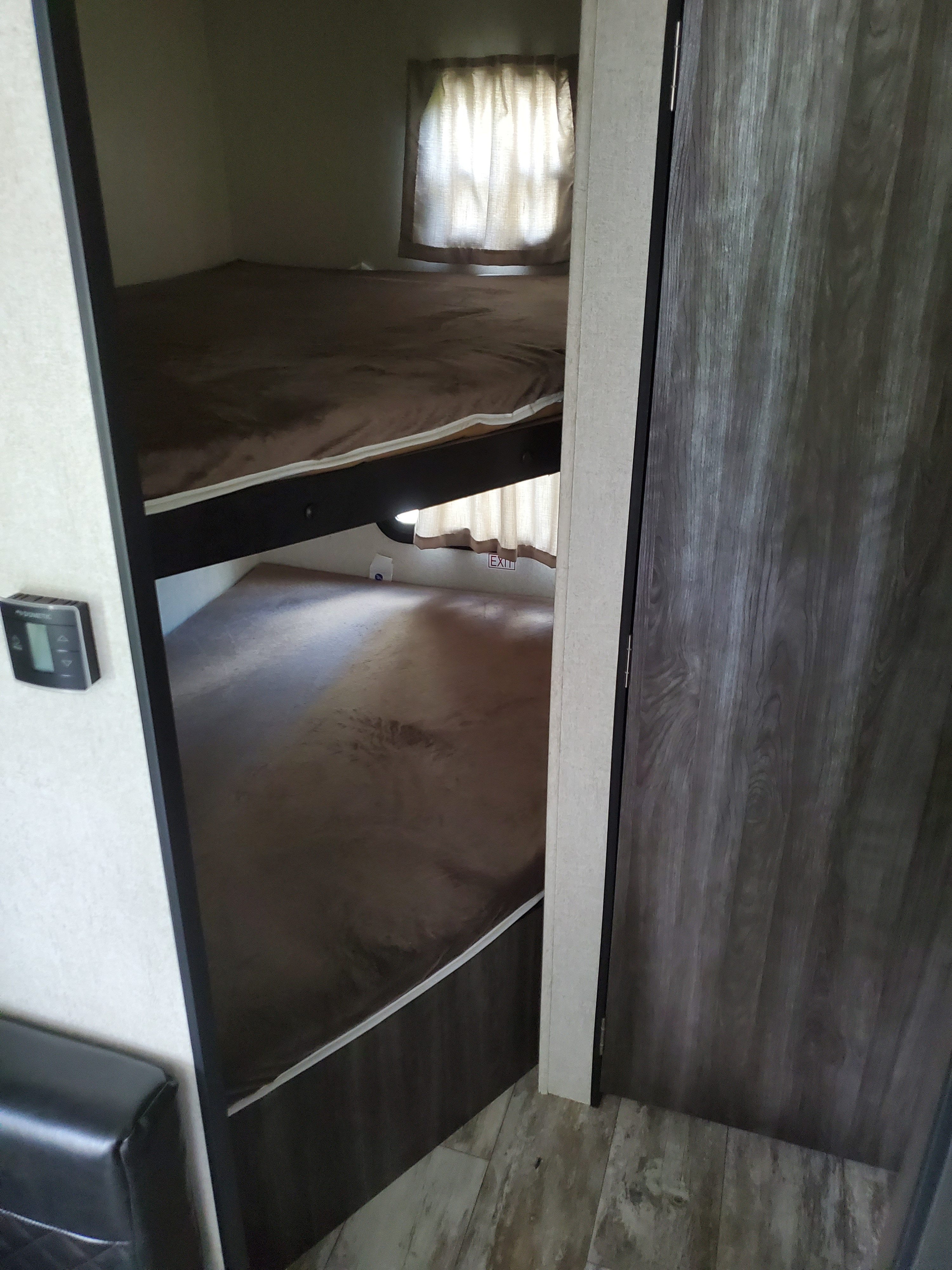 Bunk beds in an rv rental, with a window, exit sign, and climate control. Perfect for family trips.. Highland Ridge RV Open Range 2019