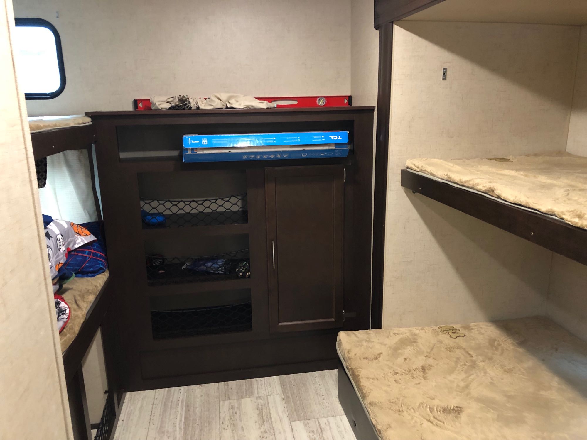 RV rental interior showing dark wood bunk beds & central storage unit. Perfect for families in a camper or travel trailer.. K-Z Manufacturing Sportsmen 2018