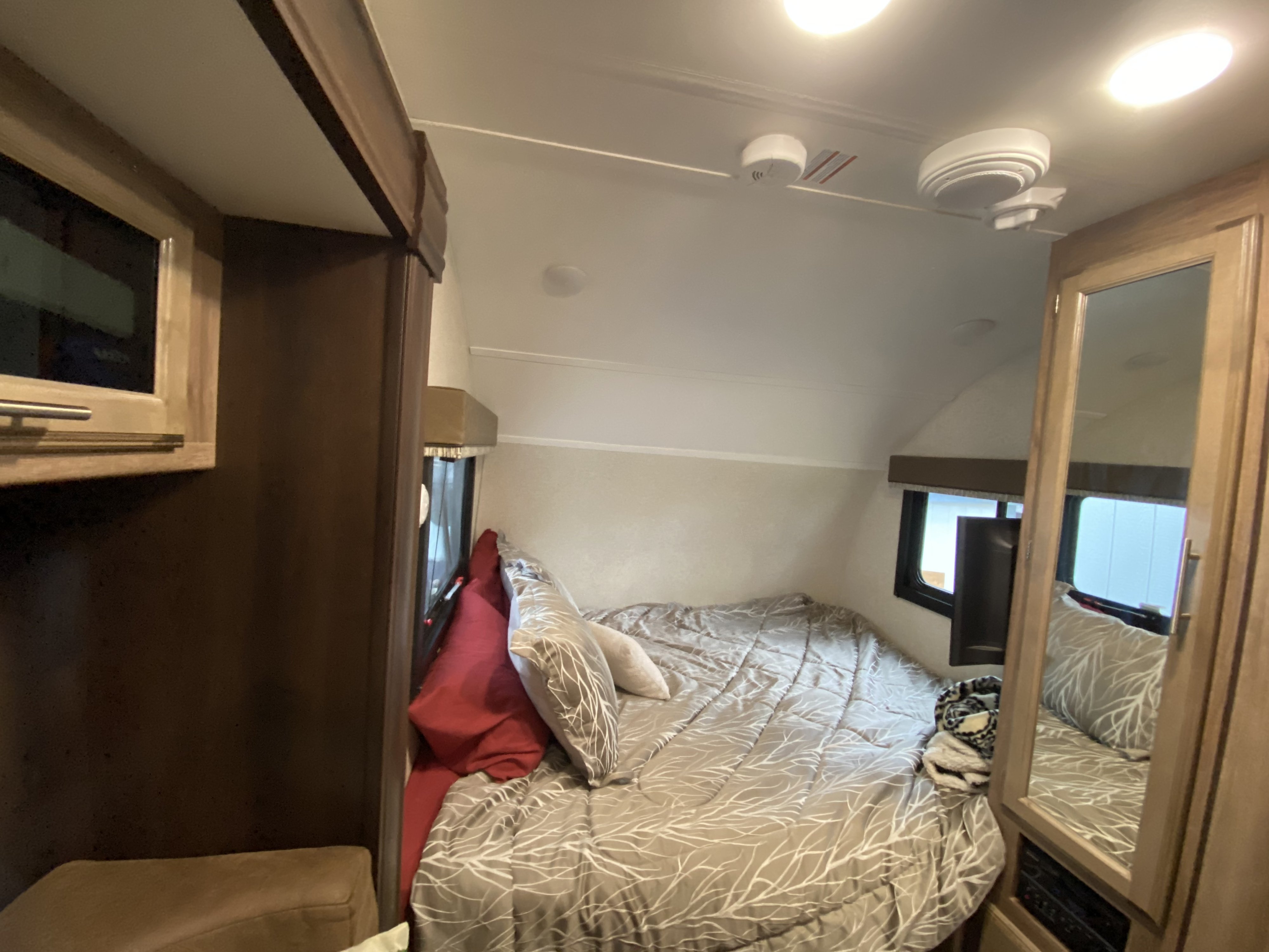 Cozy RV rental bedroom with a comfy bed, windows, and functional cabinetry, inviting rest on your travels.. Jayco Baja 2018