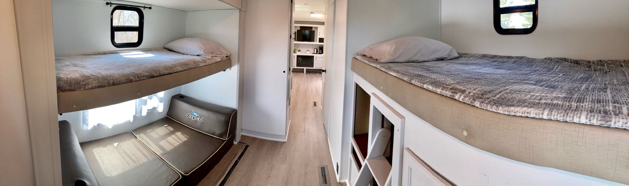 Cozy RV rental interior showcasing bunk beds, lower seating, and a hallway to the living area. Ideal for family trips.. Jayco Jay Flight 2016