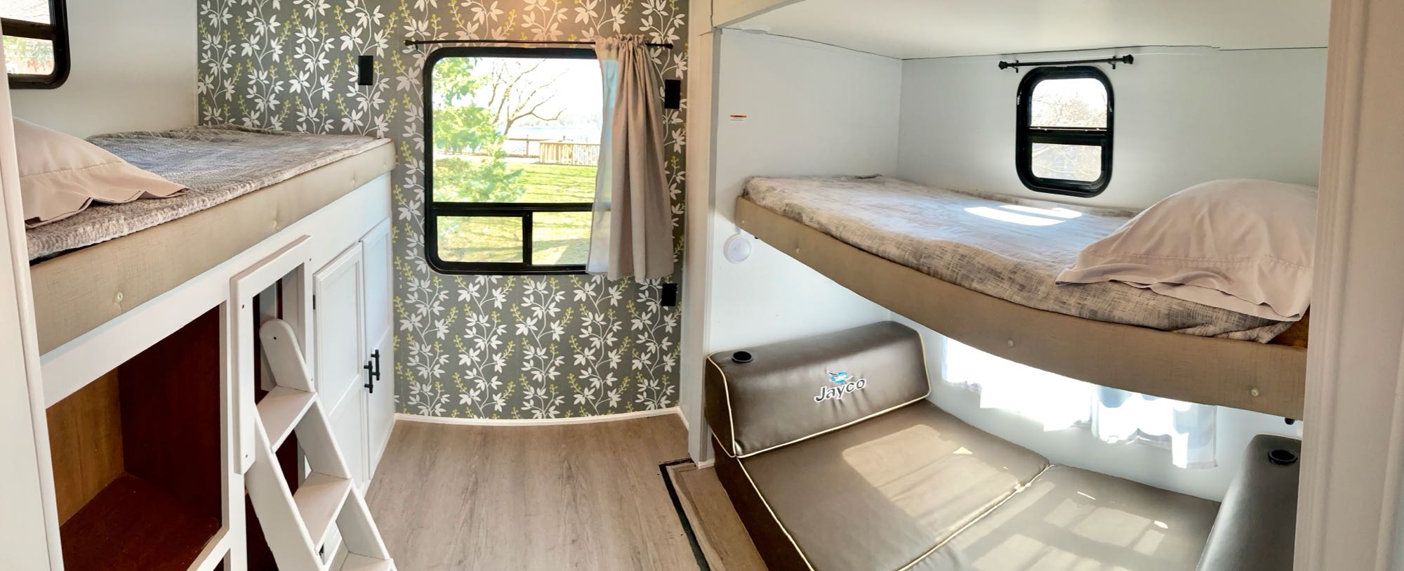 Experience a cozy RV rental bunkhouse: two sets of bunk beds, a Jayco lounge, scenic windows & stylish leaf wallpaper.. Jayco Jay Flight 2016
