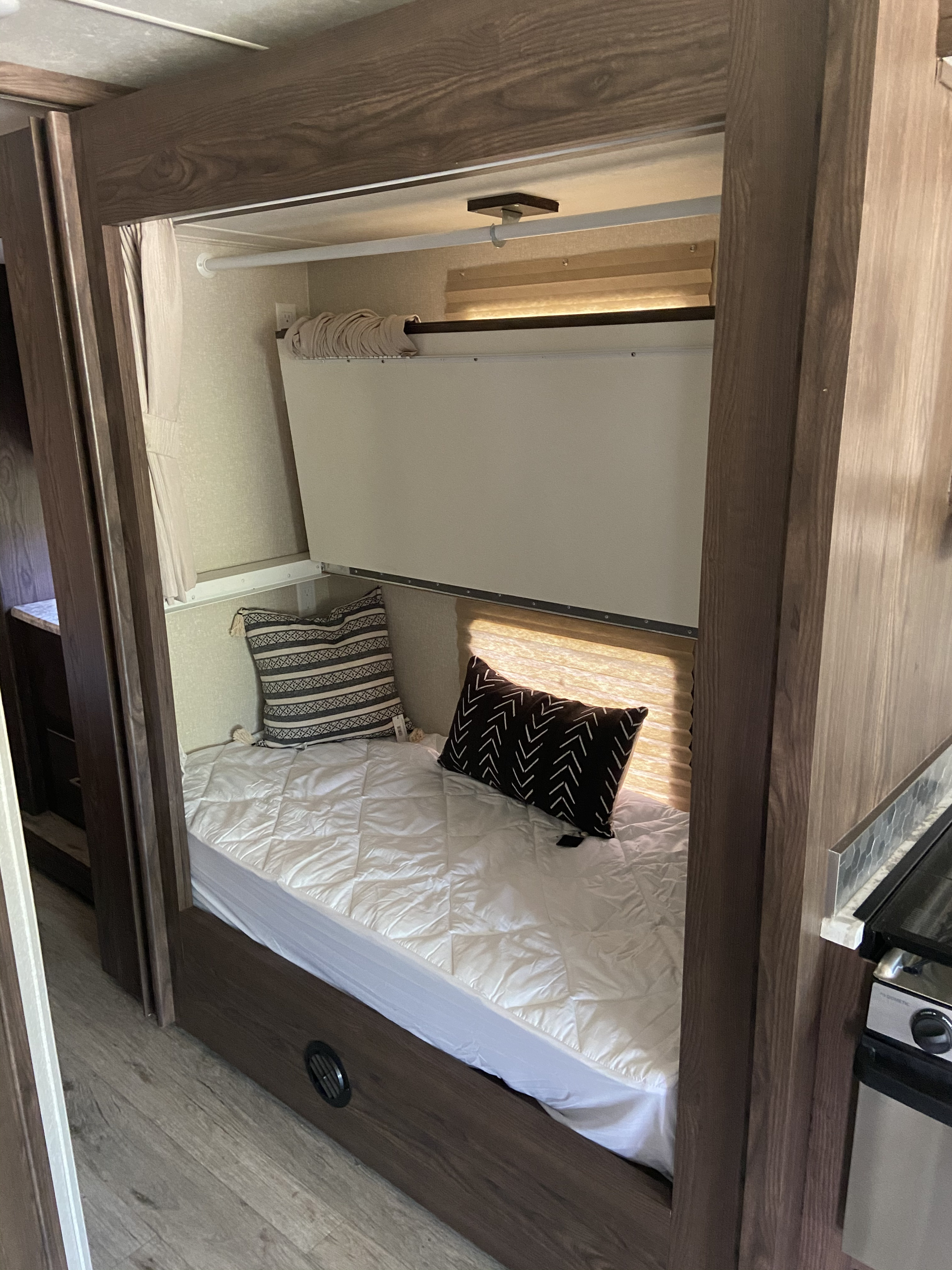 RV rental interior: cozy bunk beds with pillows and quilt, designed for comfortable, compact sleeping.. Coachmen Pursuit 2019