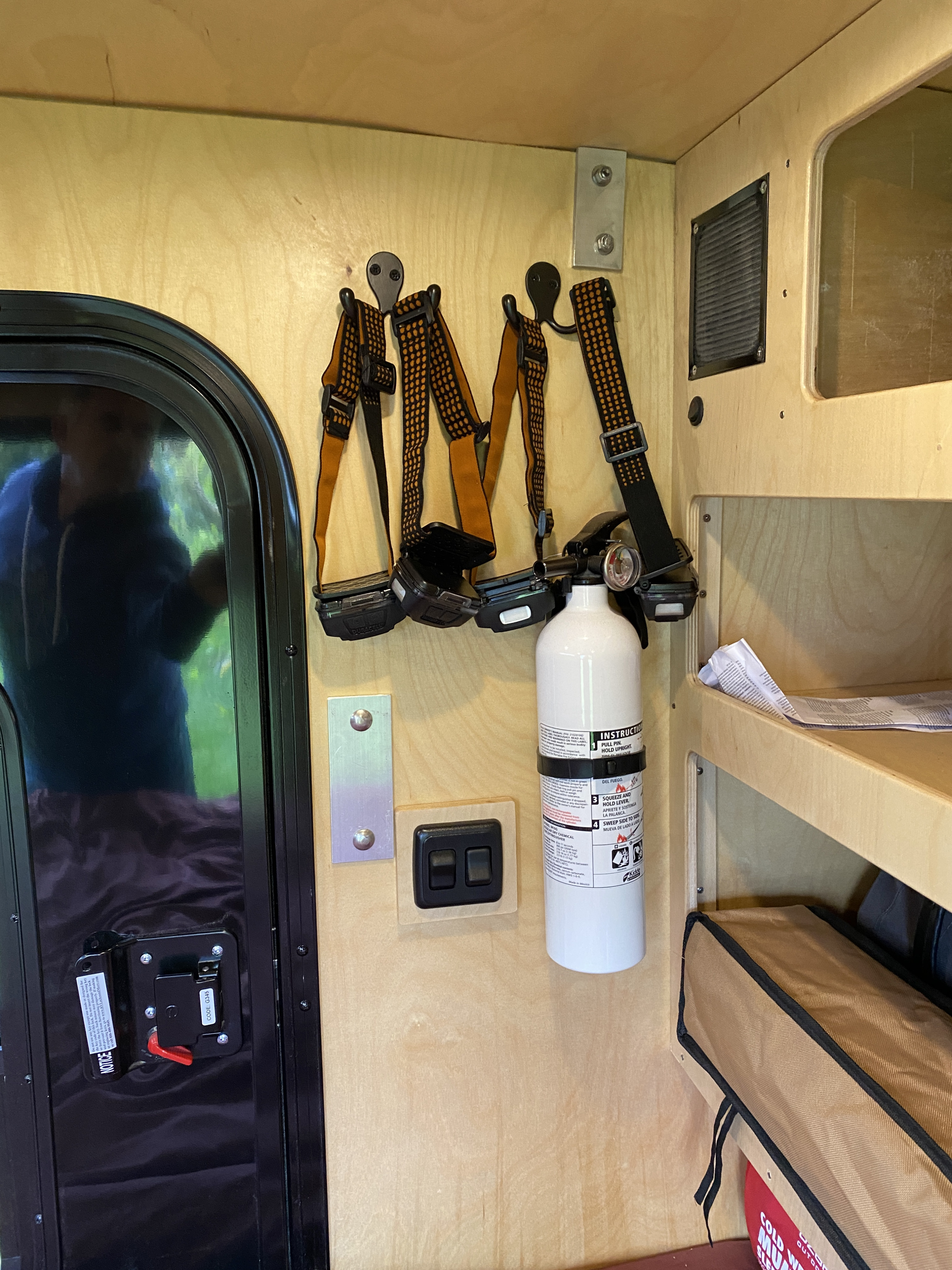 RV rental ready for adventure: headlamps, a fire extinguisher, and organized storage inside a compact camper. Safety first!. Toedrop Manufacturing LLC Teardrop 2021
