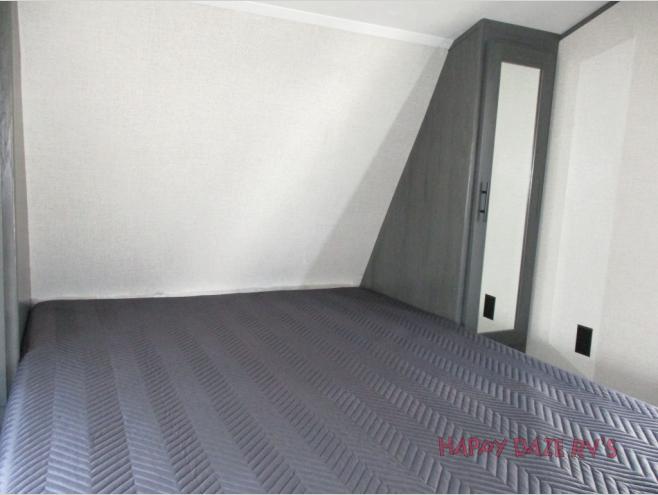 Spacious RV rental bedroom with a comfy bed and built-in mirrored wardrobe, perfect for your next mobile adventure.. Dutchmen Colorado 2021