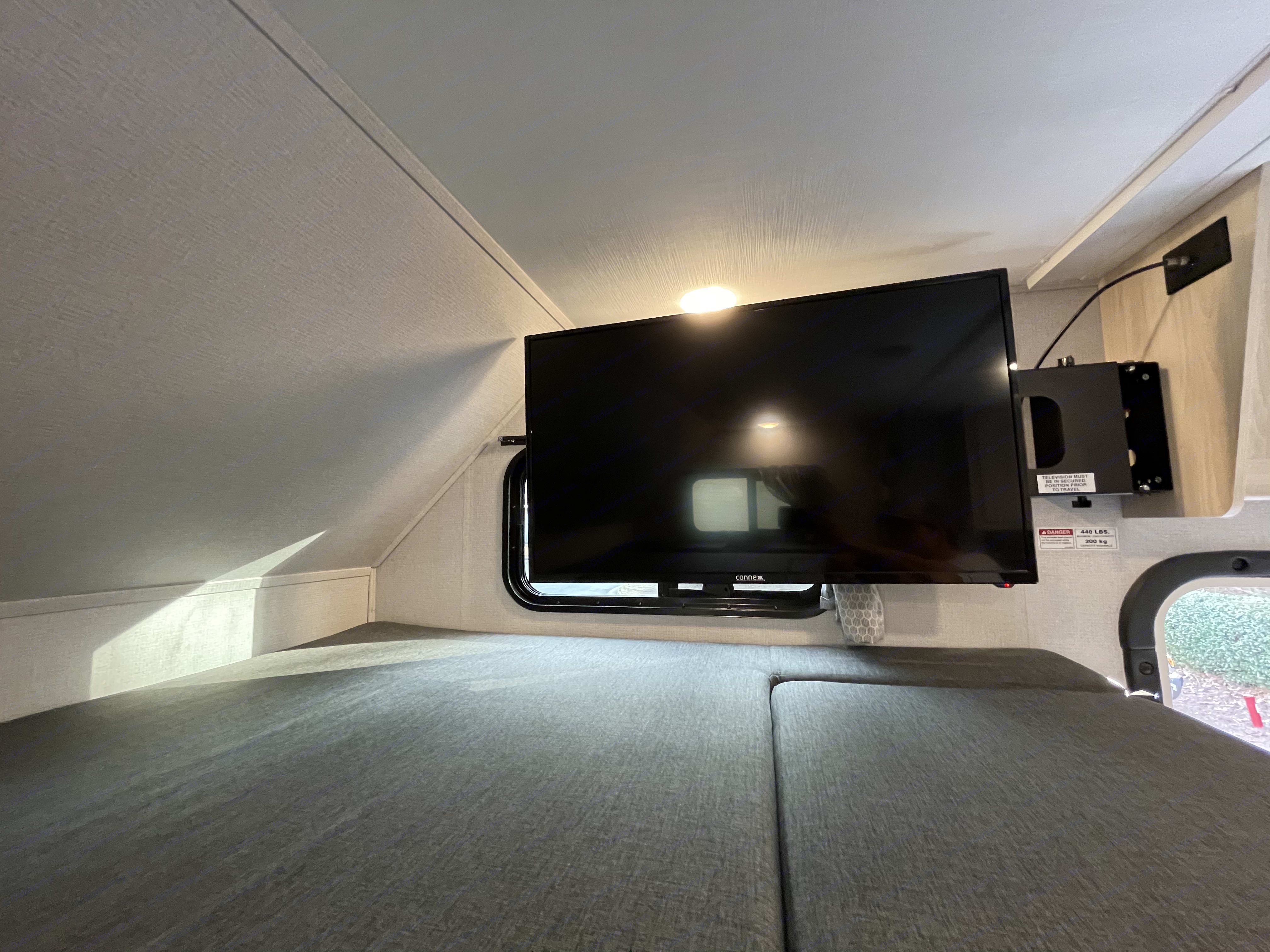 RV rental interior: a comfy bunk area with a mounted TV (secure for travel) and 440 lbs weight limit.. Forest River Forester 2021