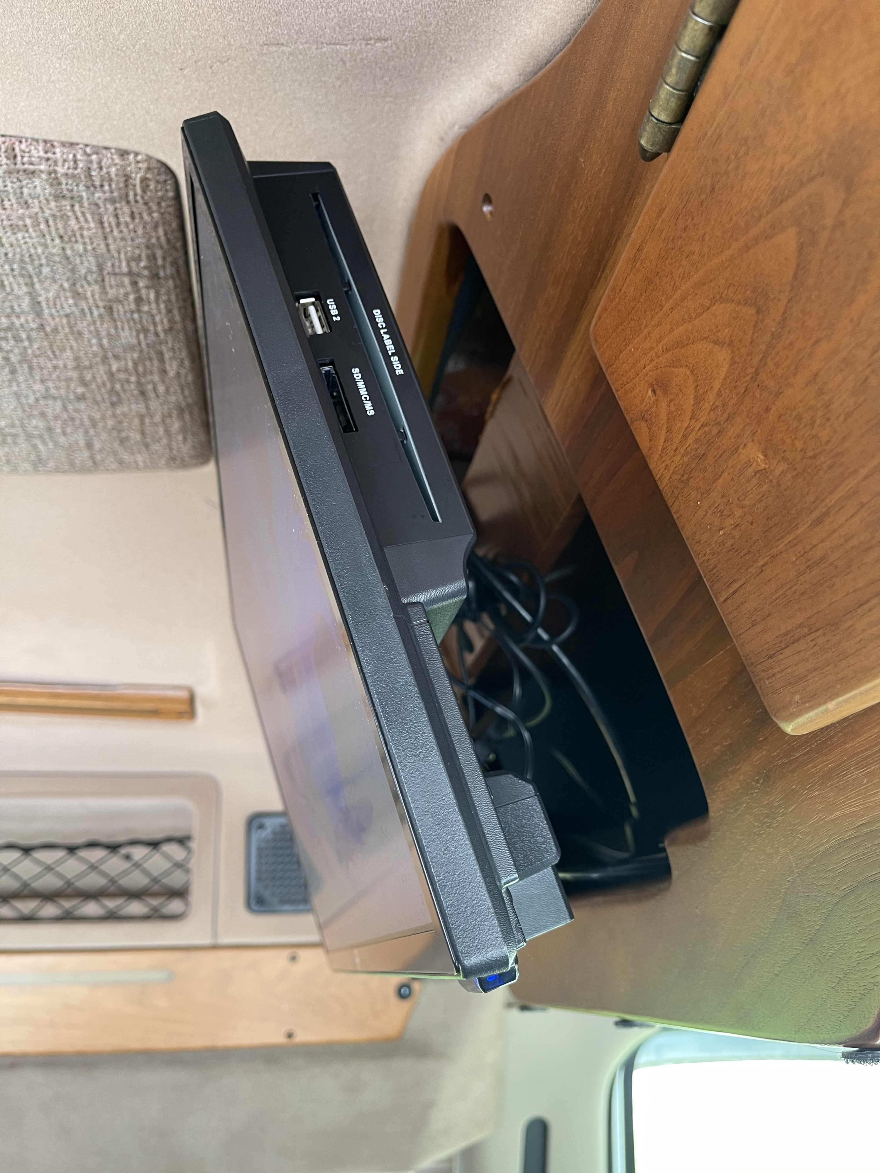Side view of an RV rental entertainment system: a mounted media player with USB, SD, and disc slots for in-vehicle viewing.. Coachmen Van Conversion 2001