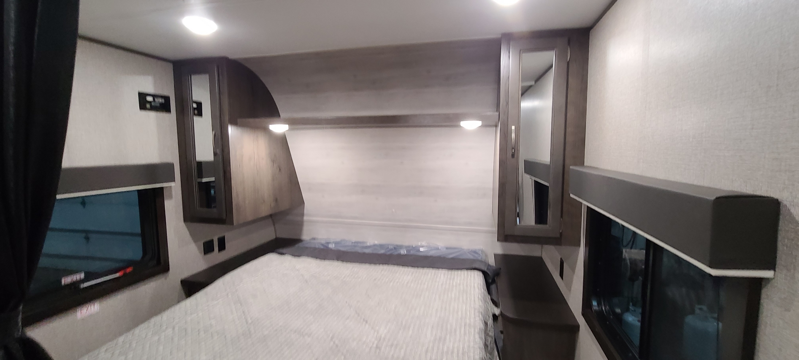 This RV rental bedroom features a cozy bed, built-in storage, and windows, ideal for travel adventures.. Jayco Jay Flight 2021