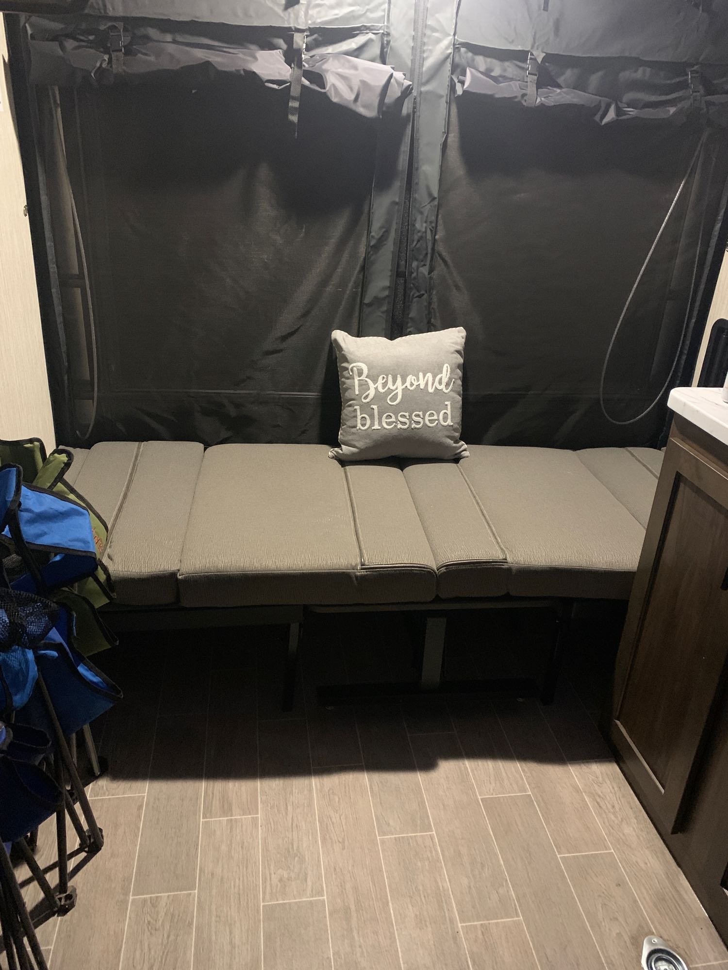 Cozy RV rental interior with grey seating/bed, black canvas walls, and wood-look floor, ideal for travel.. Forest River Wolf Pup 2021
