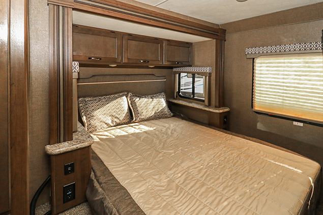 Comfortable RV rental bedroom with a cozy bed, overhead storage, and convenient outlets for your travels.. Thor Motor Coach Freedom Elite 2019