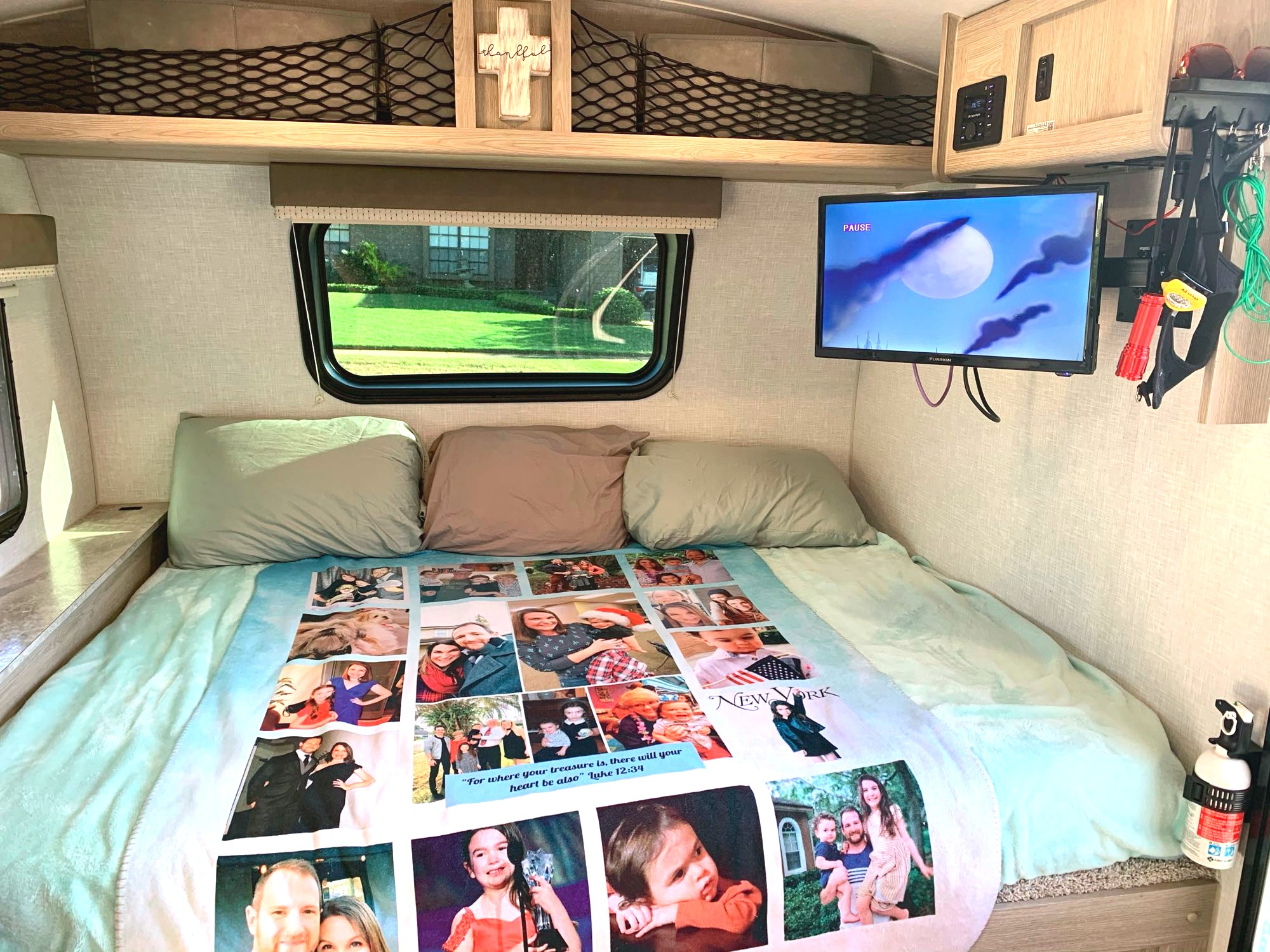 Cozy RV rental interior with a personalized photo blanket on the bed, TV, window view, and overhead storage.. Forest River Other 2021