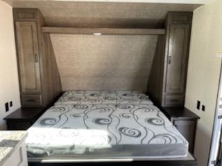 RV rental: Bright view of an RV bedroom showing a bed, integrated nightstands, and tall storage cabinets.. Open Range Open Range 2021