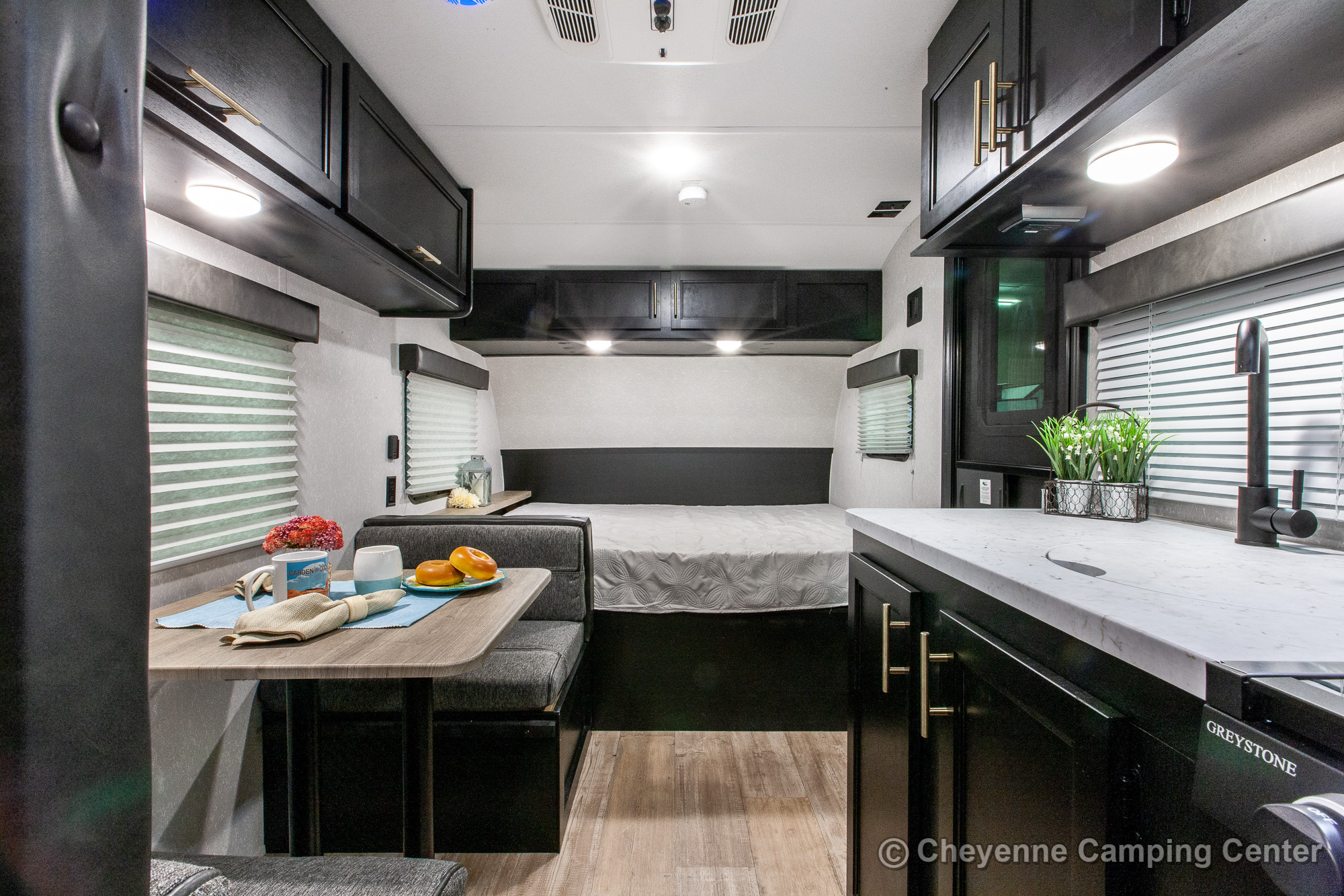 Inside a modern RV rental, featuring a compact dining area, kitchen counter, and rear bed for comfortable travel.. Forest River Cherokee Wolf Pup 2021