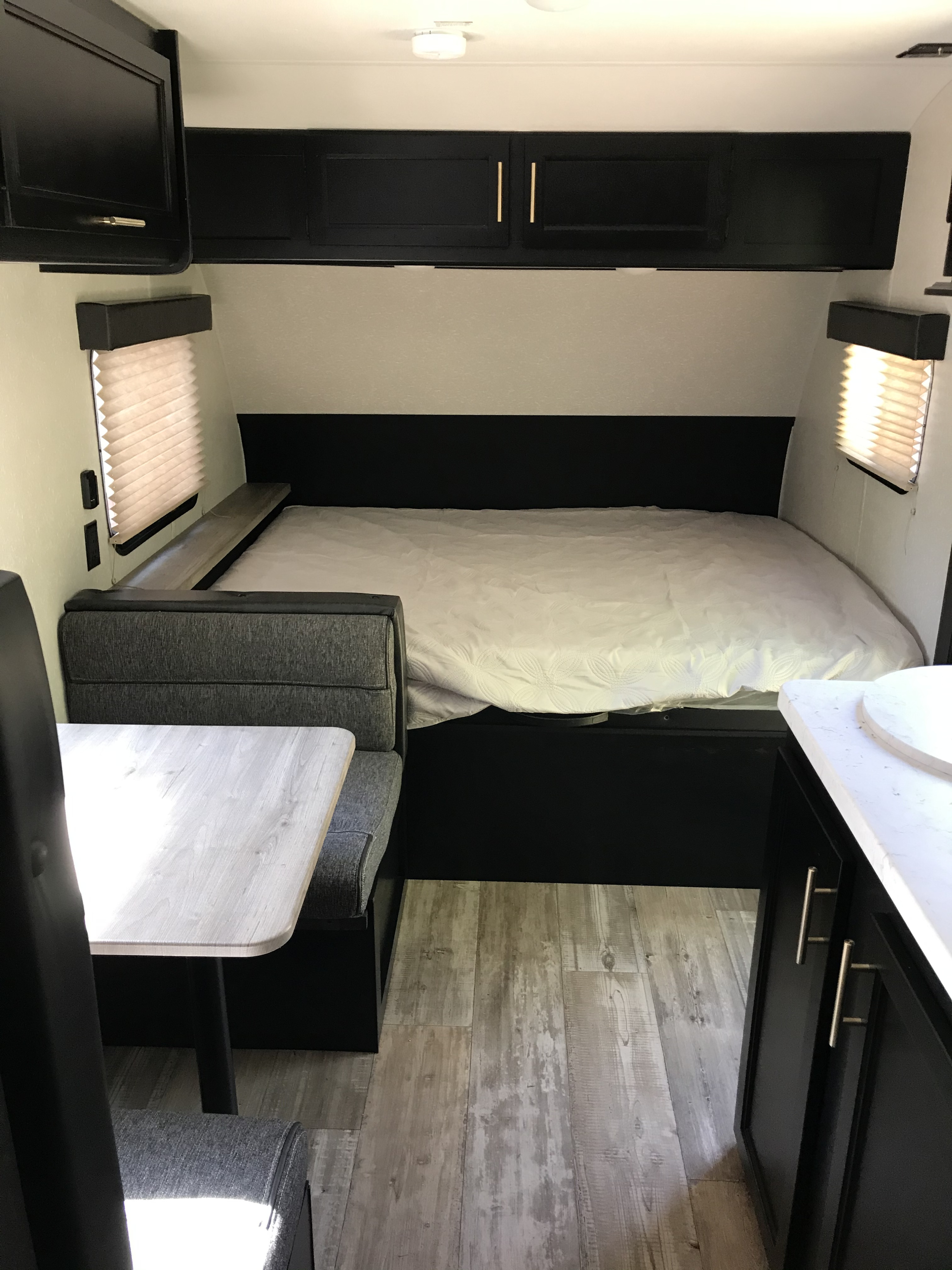 RV rental: Modern RV interior featuring a bed, cozy dinette, and overhead cabinets for compact living.. Forest River Wolf Pup 2021