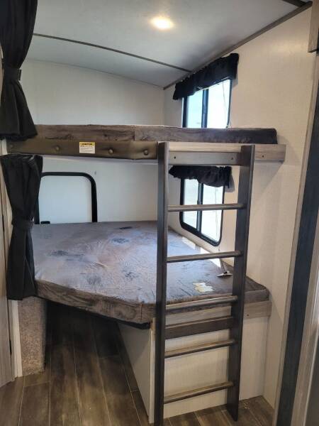 RV rental: Bunk beds with a ladder dominate this interior view, offering a functional and cozy sleeping area.. Keystone Passport 2021