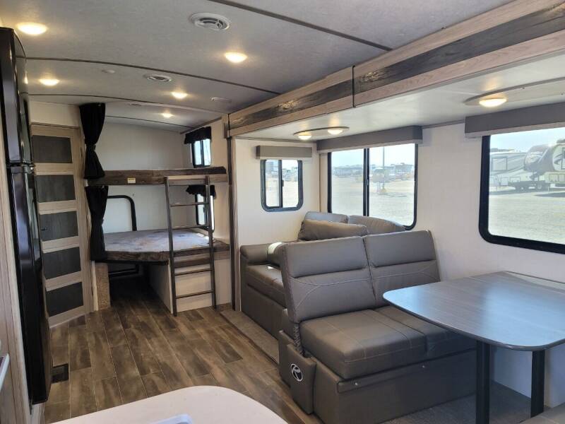 Spacious RV rental interior featuring bunk beds, a dinette, and sofa seating, perfect for family travel.. Keystone Passport 2021