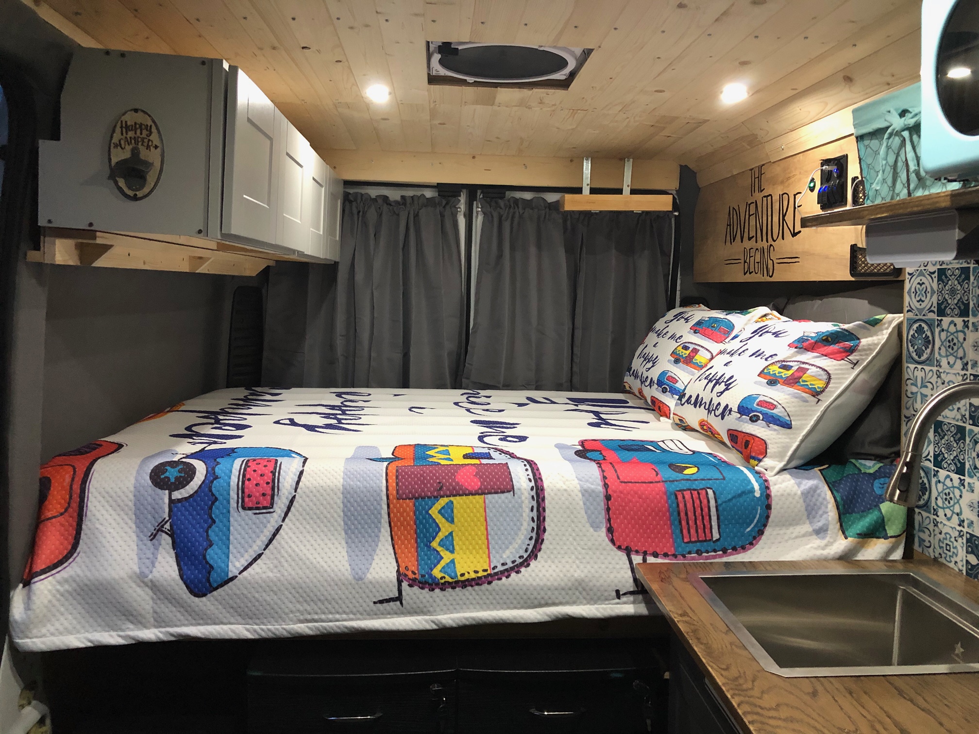 Inviting rv rental interior with "The Adventure Begins" sign, bed, sink, and storage, perfect for travel.. Dodge Ram 1500 2019