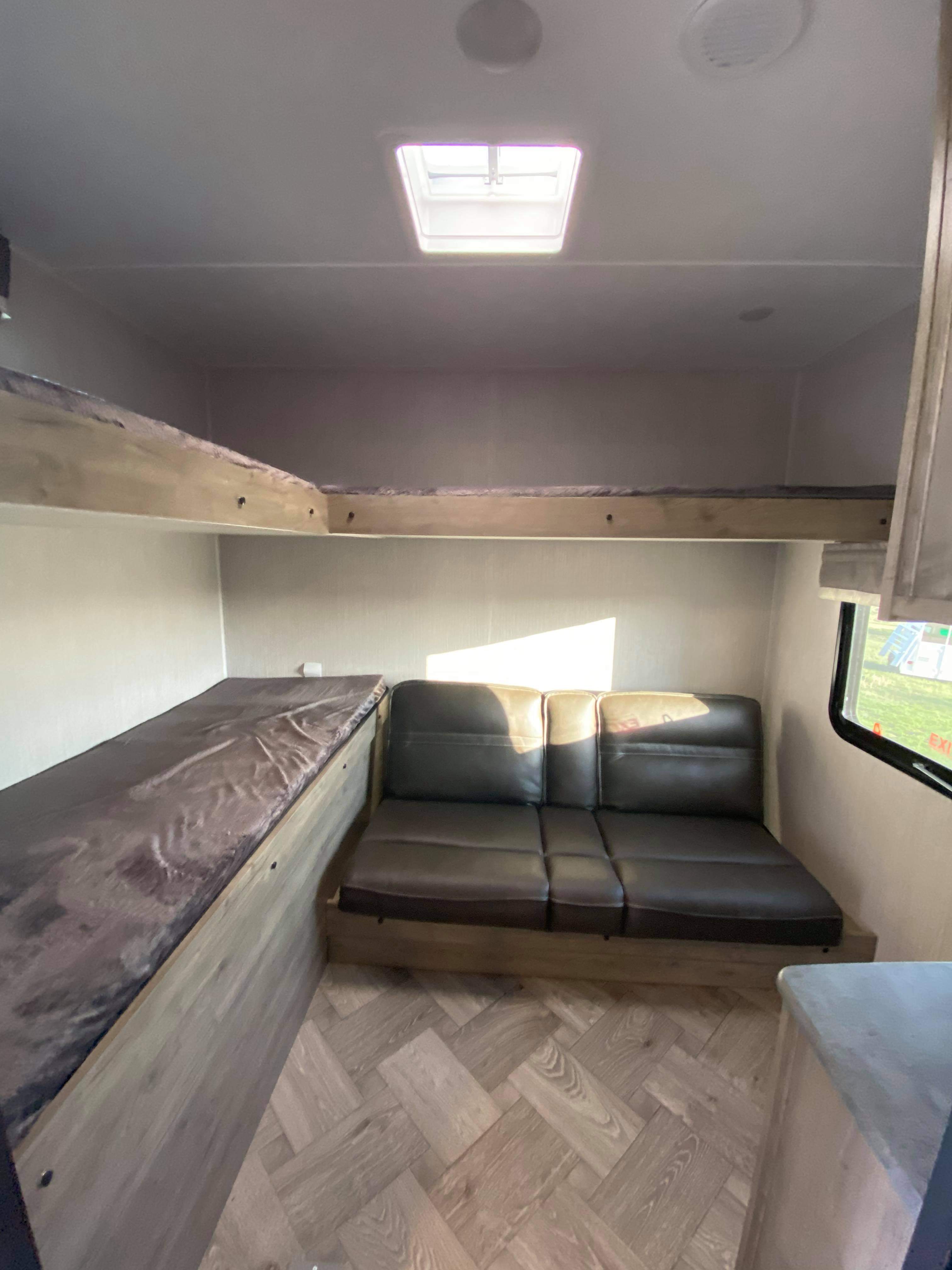 RV rental interior: cozy living space with bunk beds, sofa, and skylight. Perfect for family adventures.. Palomino Puma 2021
