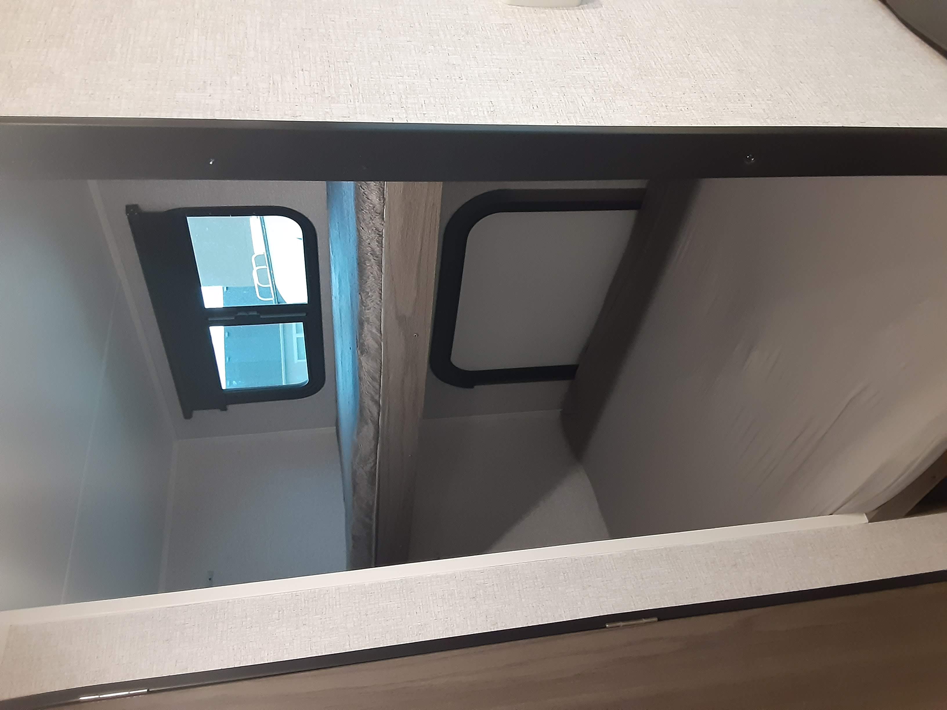 RV rental bunk beds. View from a lower bunk shows the top bunk's support structure and window, perfect for compact sleeping.. Dutchmen Kodiak 2021