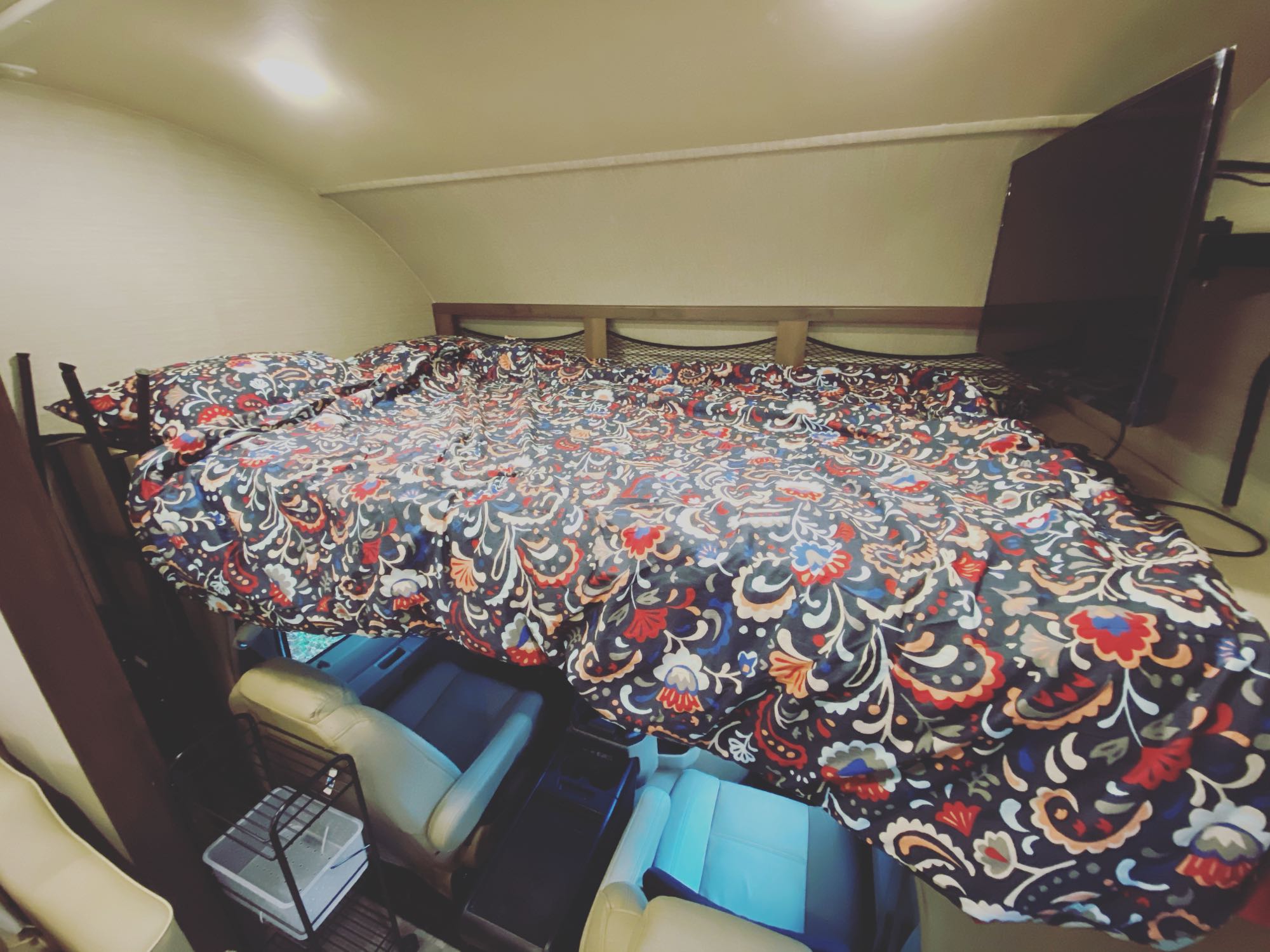 Cozy RV rental cab-over bed with colorful bedding & TV. Perfect motorhome sleeping area above the driver's cabin.. Jayco Redhawk 2020