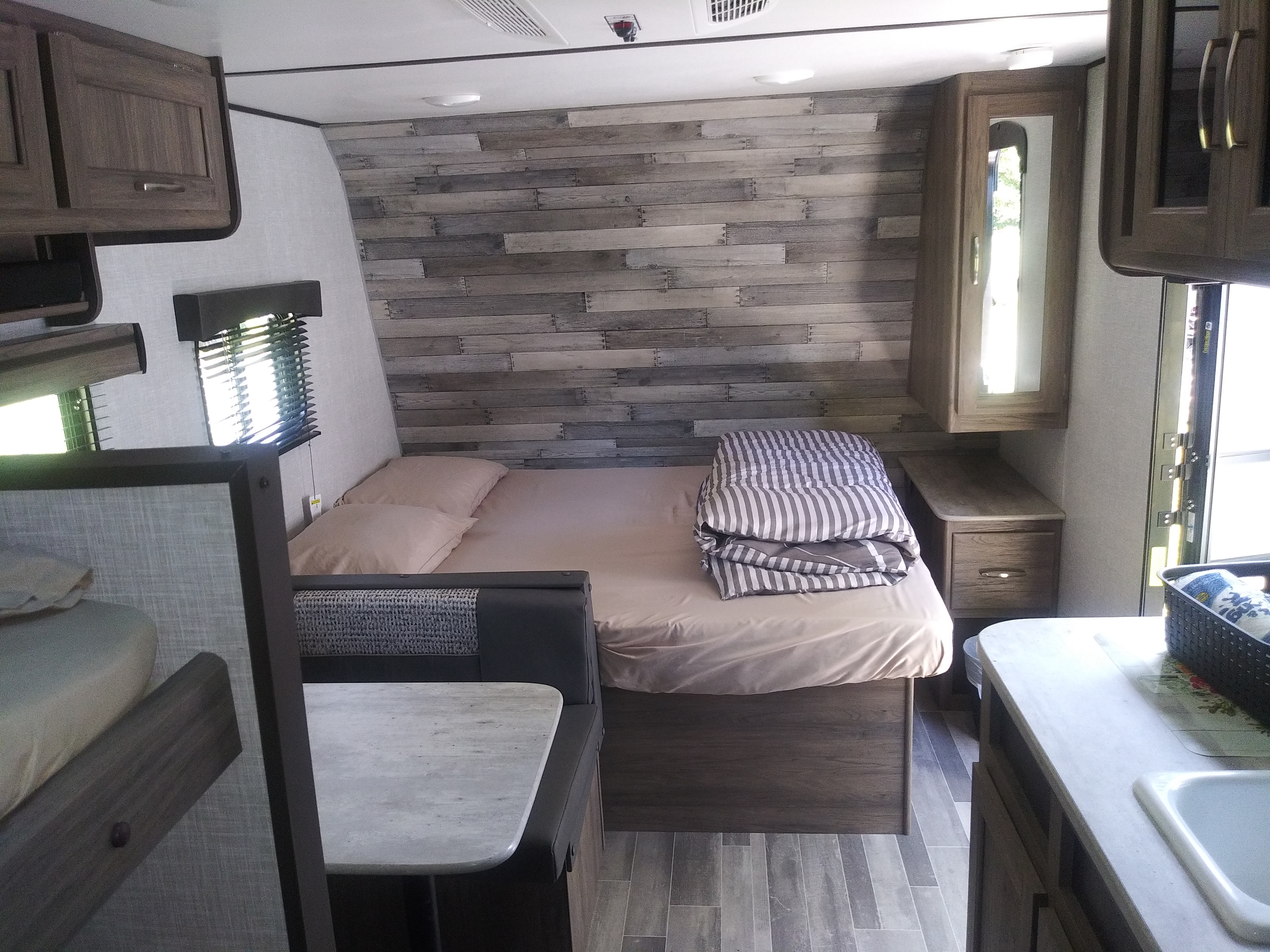 RV rental interior: a modern space with a bed, dinette, and partially visible kitchen/bunk area.. Crossroads RV Zinger Lite 2021