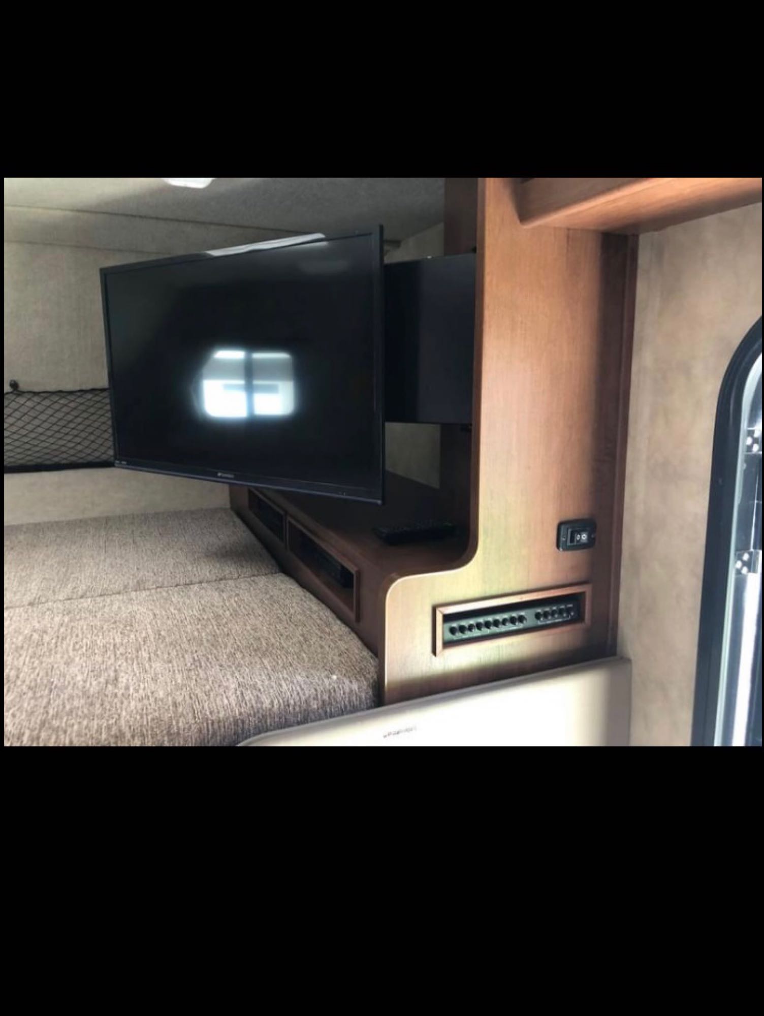 RV rental interior: A cozy bed and swivel TV, with a nearby control panel & storage, offer comfort for your journey.. Fleetwood Jamboree Sport 2014