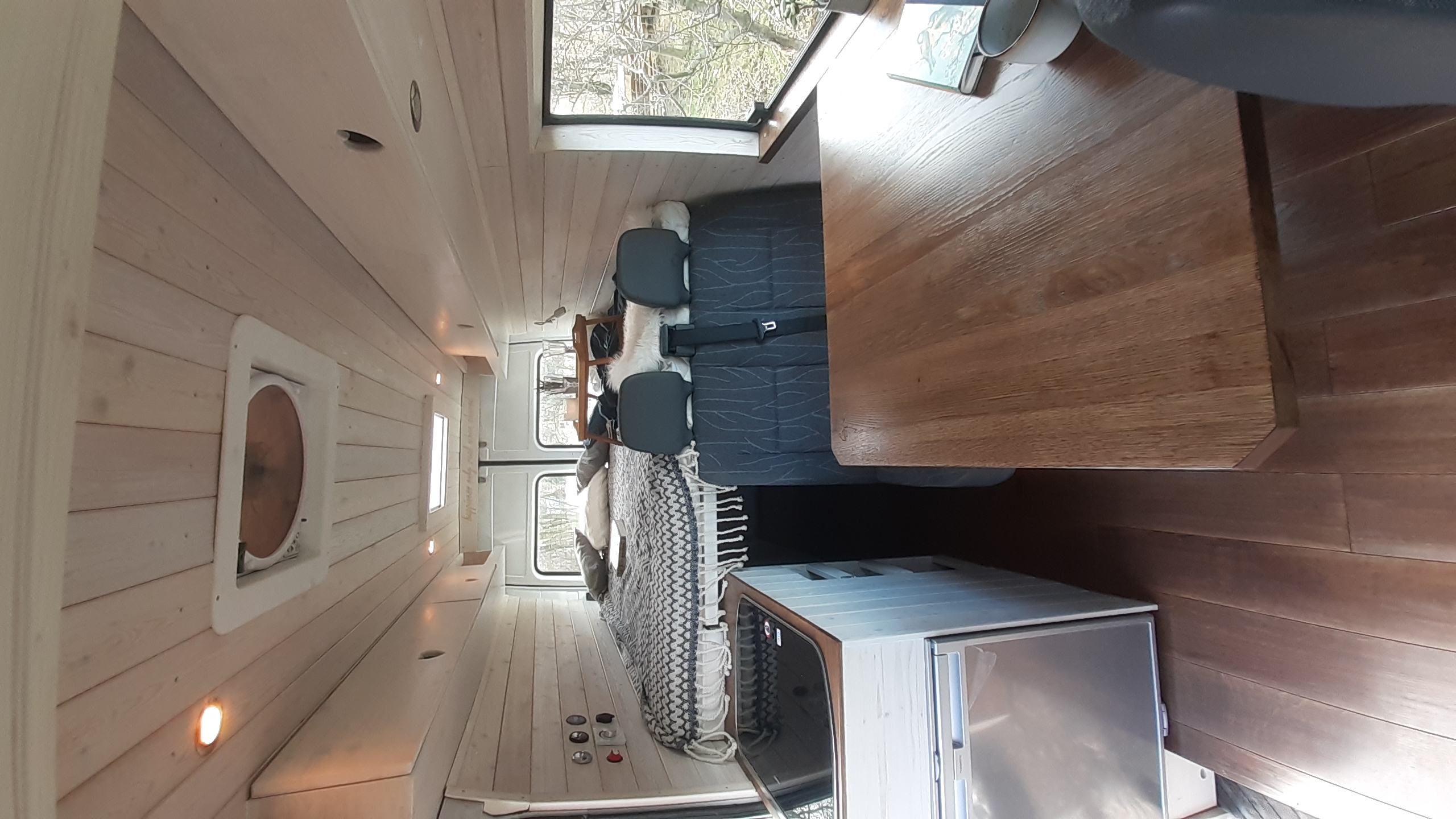 RV rental: Bright, modern camper van interior with wood finishes, ample seating, bed, and kitchen.. Mercedes-Benz Sprinter 2001