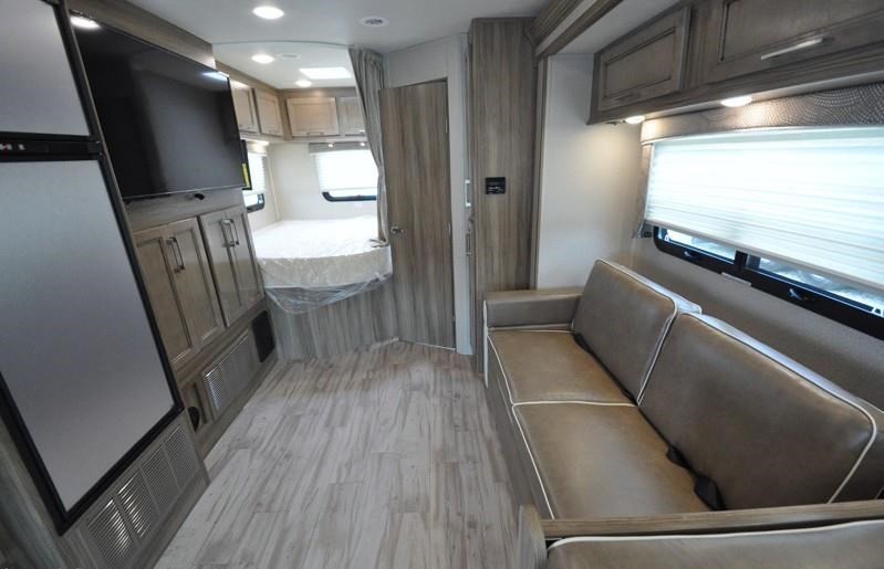 This RV rental's inviting interior features a living area with a sofa and TV, a compact kitchen, and a cozy bedroom.. Entegra Coach Entegra 2020