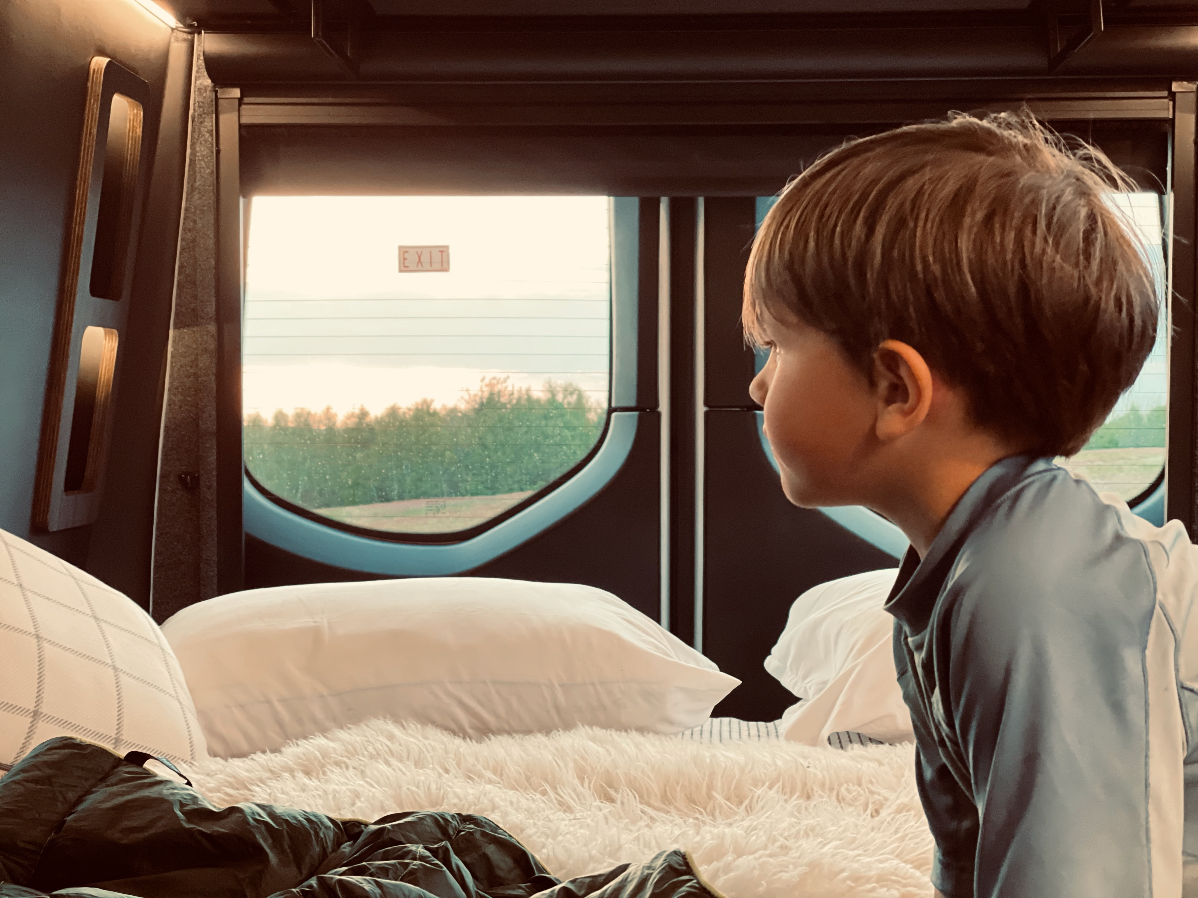 Cozy RV rental interior with a child looking out the window at scenic views. Perfect for road trip adventures.. Airstream Other 2021
