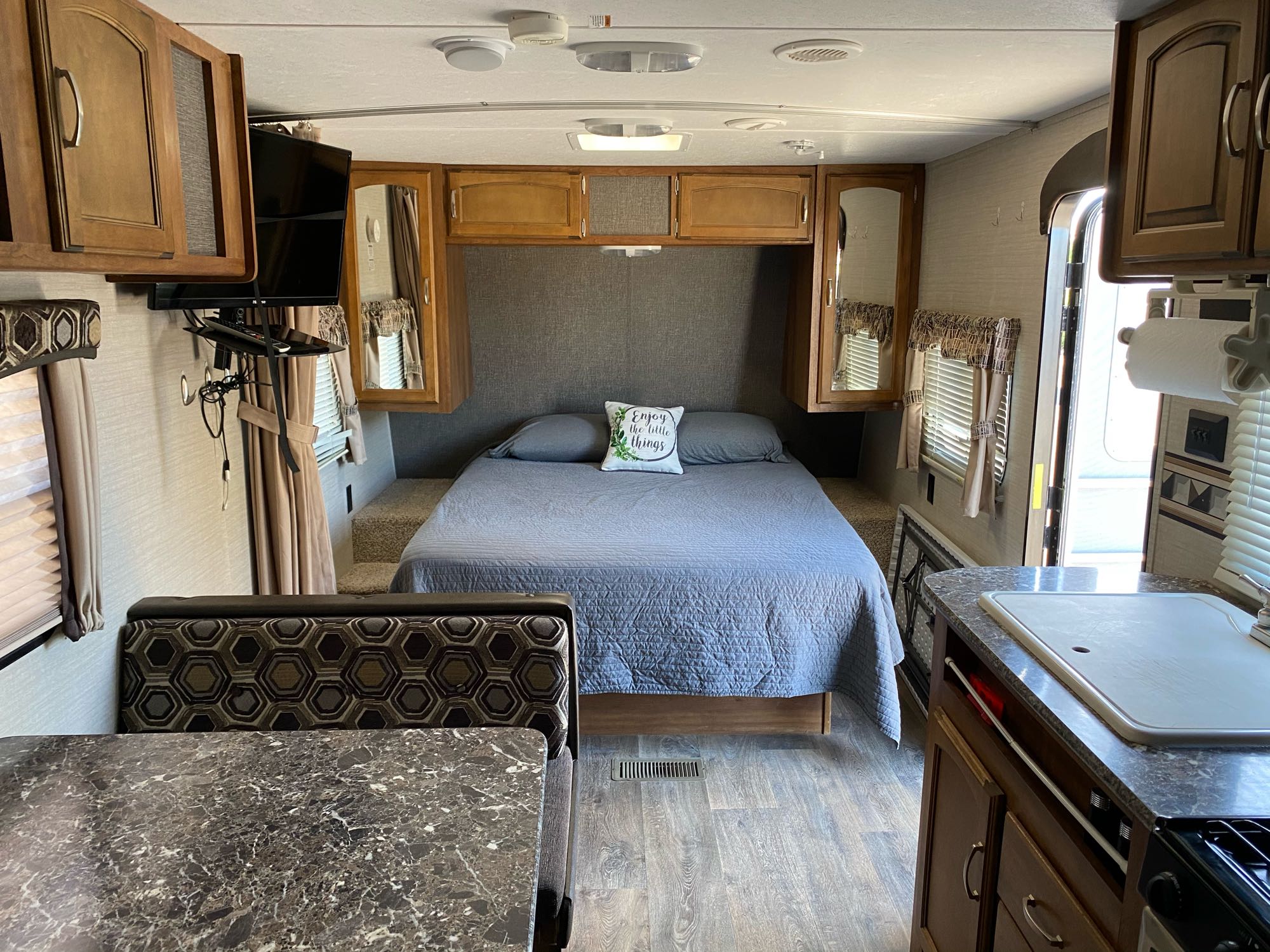 RV rental interior: a full view showing the queen bed, dining nook, and kitchen counter with sink.. Keystone Springdale 2016