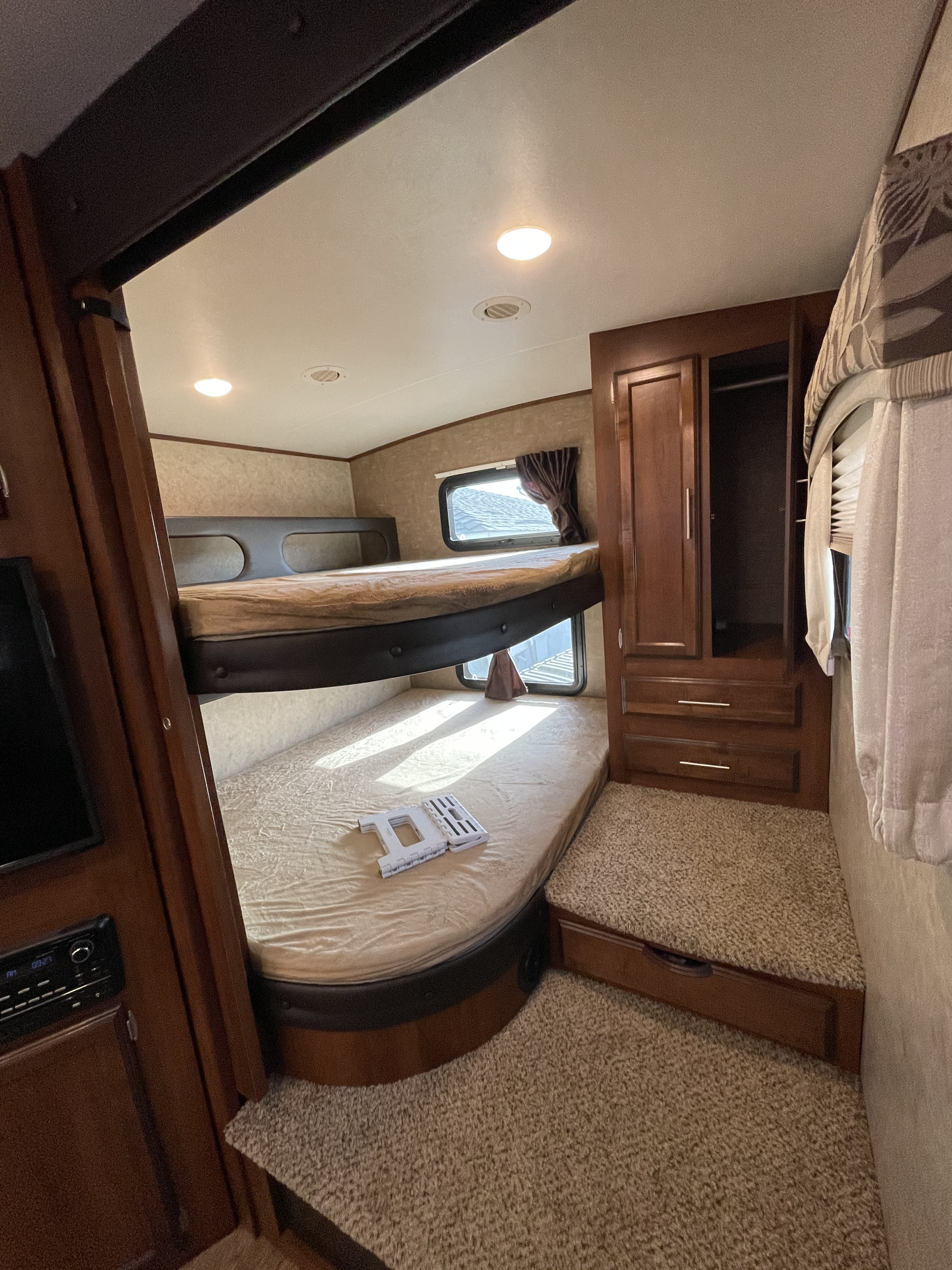 This RV rental bunkhouse features comfy bunk beds, a closet, and windows, providing a practical sleeping space.. Jayco Eagle HT 2017
