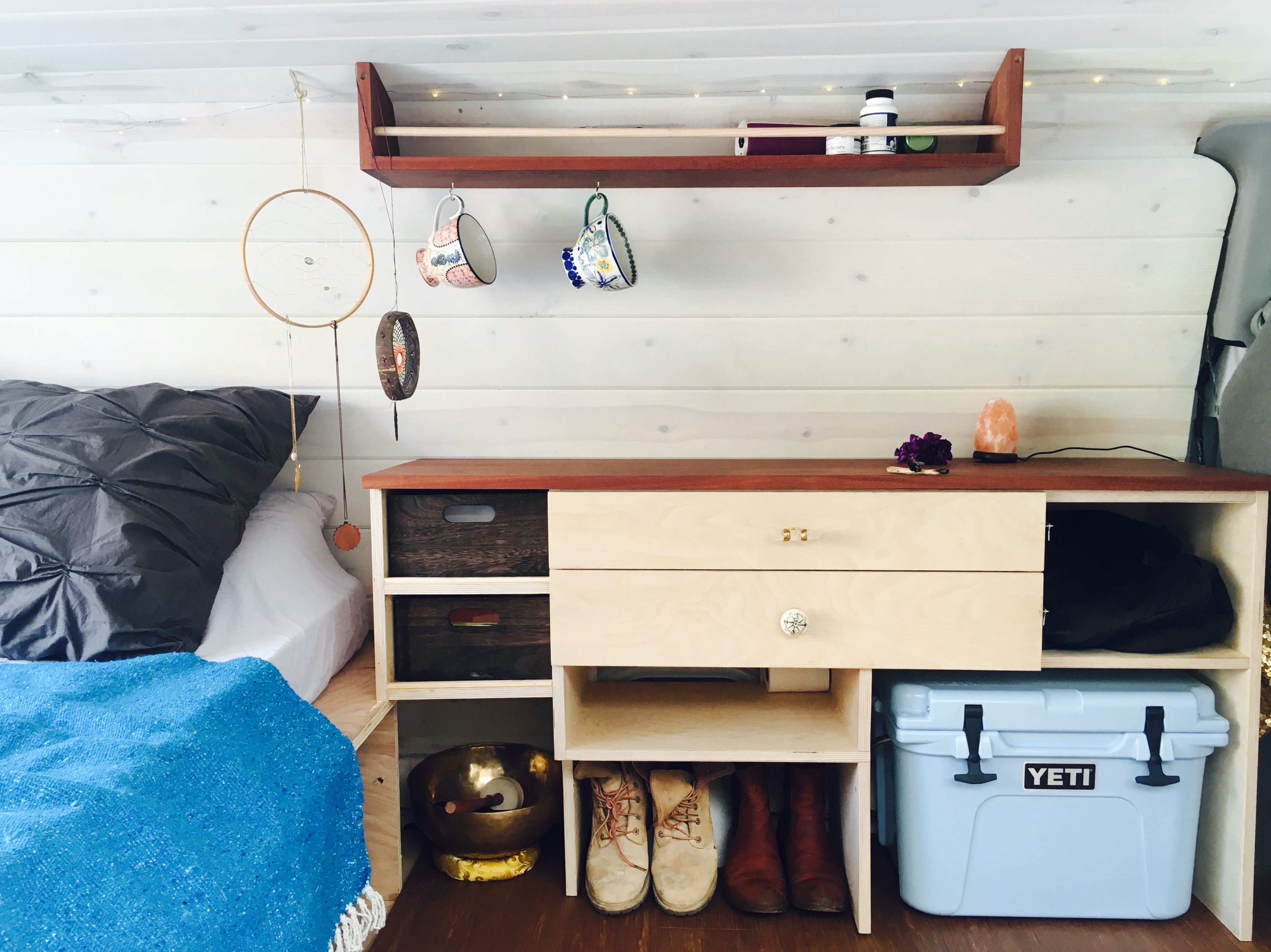 Cozy RV rental interior: Bed, custom storage, & Yeti cooler make van life comfortable.. Ford Ford E350 2011