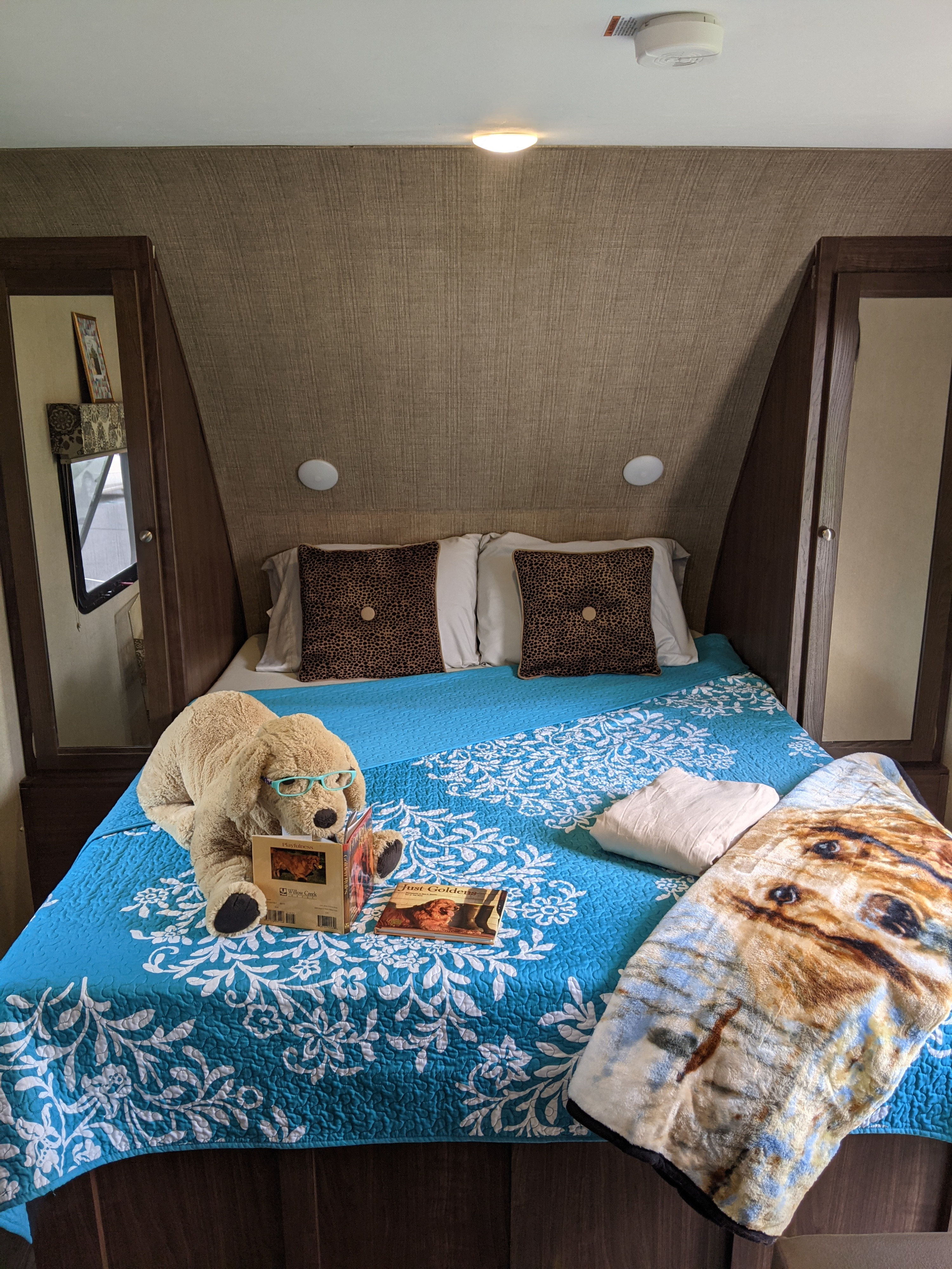 RV rental bedroom: cozy bed with blue quilt, leopard pillows, & a reading stuffed dog. Perfect for relaxation.. Other Other 2017