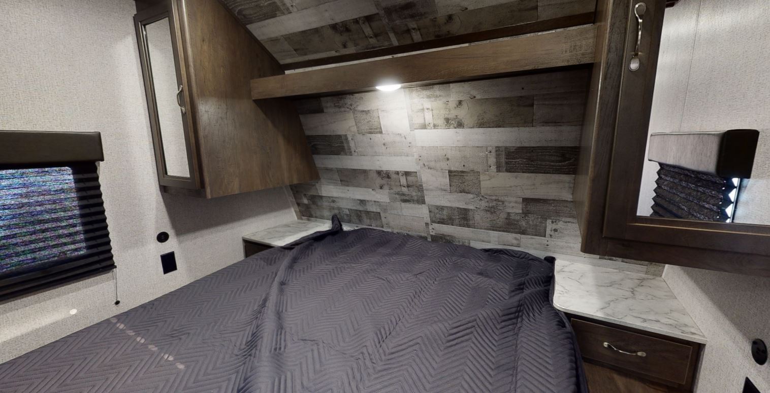 RV rental bedroom: a comfortable bed, stylish wood paneled wall, overhead cabinets, and window with blinds.. Coleman Other 2021