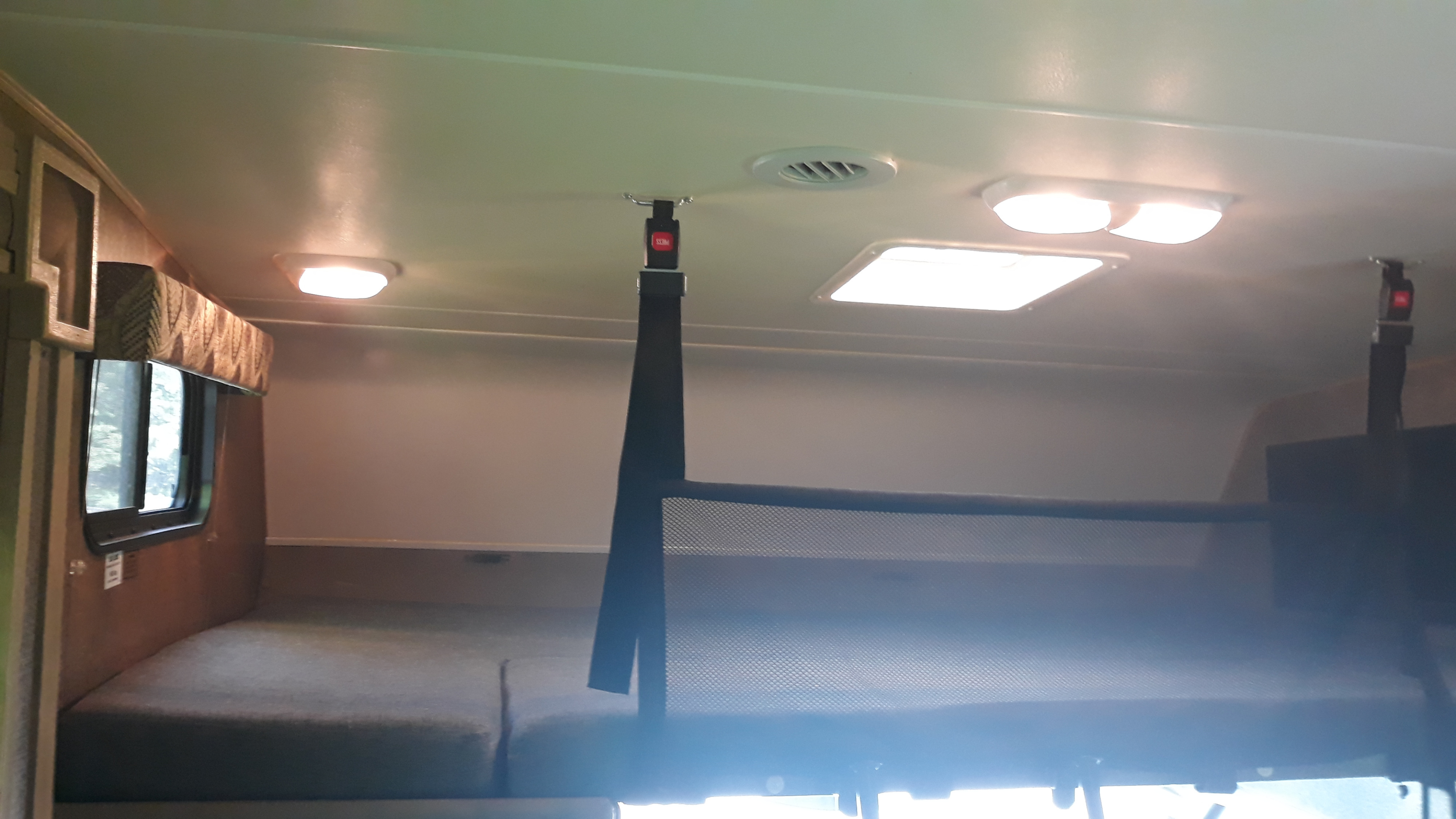 RV rental: Over-cab bunk bed with safety net, ceiling lights, and window create a functional camper interior.. Forest River Coachmen Freelander 2014