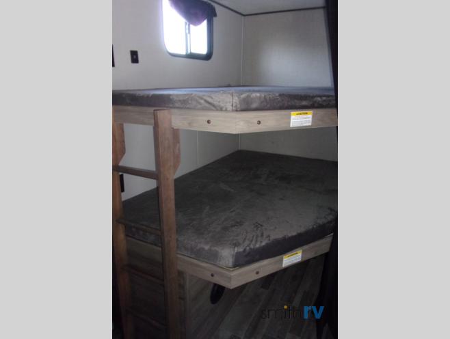 Spacious RV rental interior featuring comfortable wooden bunk beds, providing cozy sleeping arrangements for camping trips.. Crossroads Zinger 2021