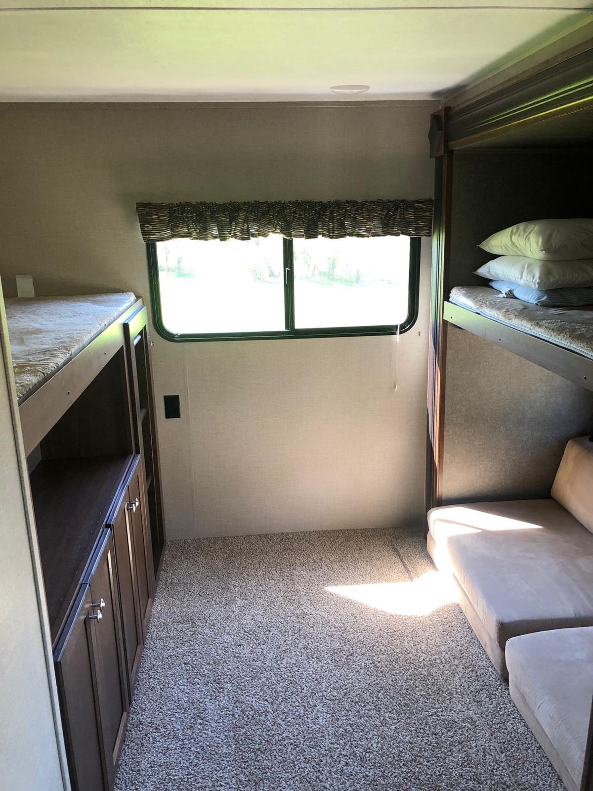 RV rental interior: bunk beds, comfortable seating, cabinetry, and a large window for natural light.. Keystone Hideout 32 BHTS 2017